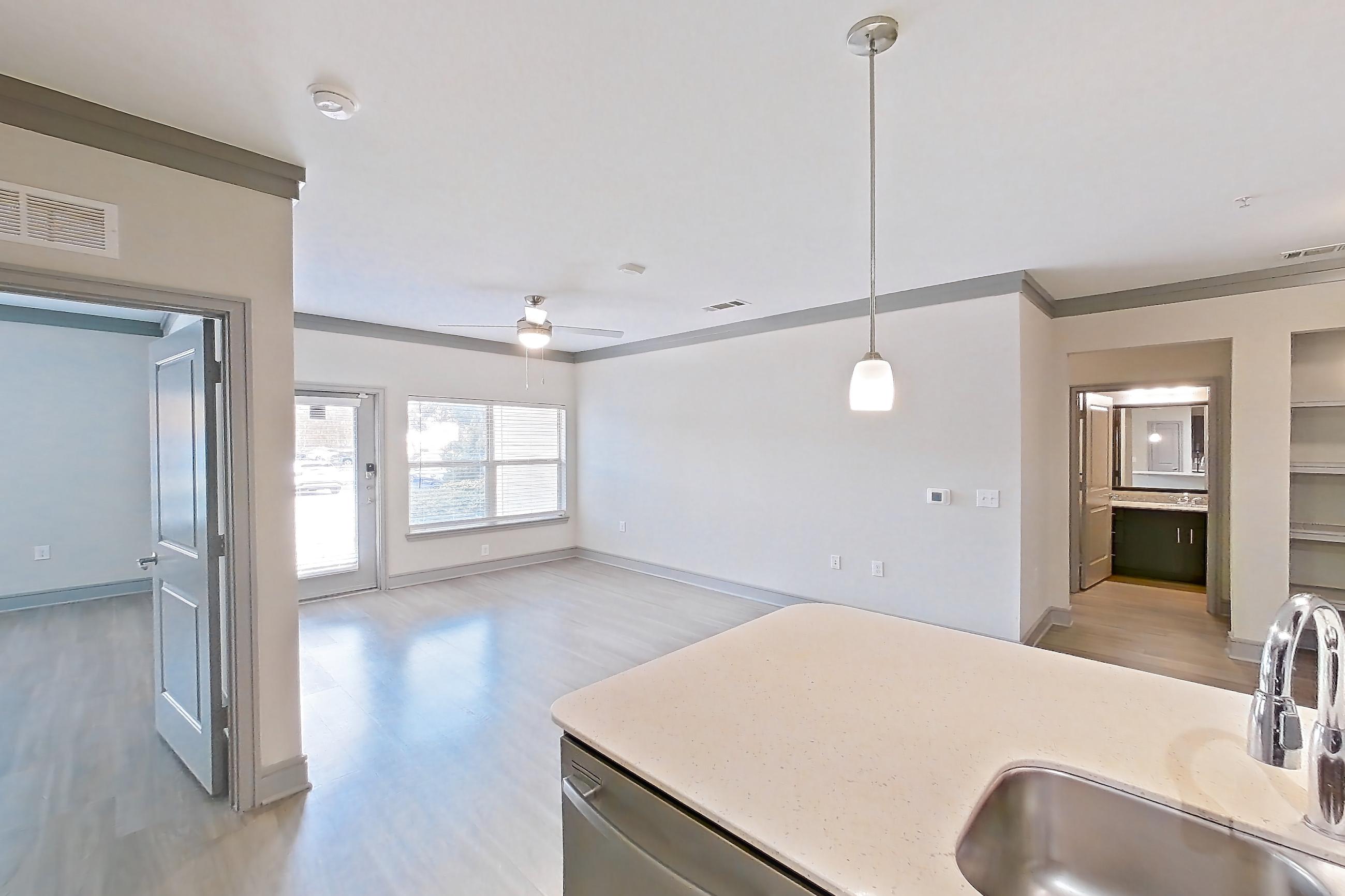 Kitchen with dishwasher, light stone countertops, light wood-finish flooring, refrigerator, stainless steel appliances, and water & ice dispenser, Apartment 3104 at Cortland Phillips Creek Ranch