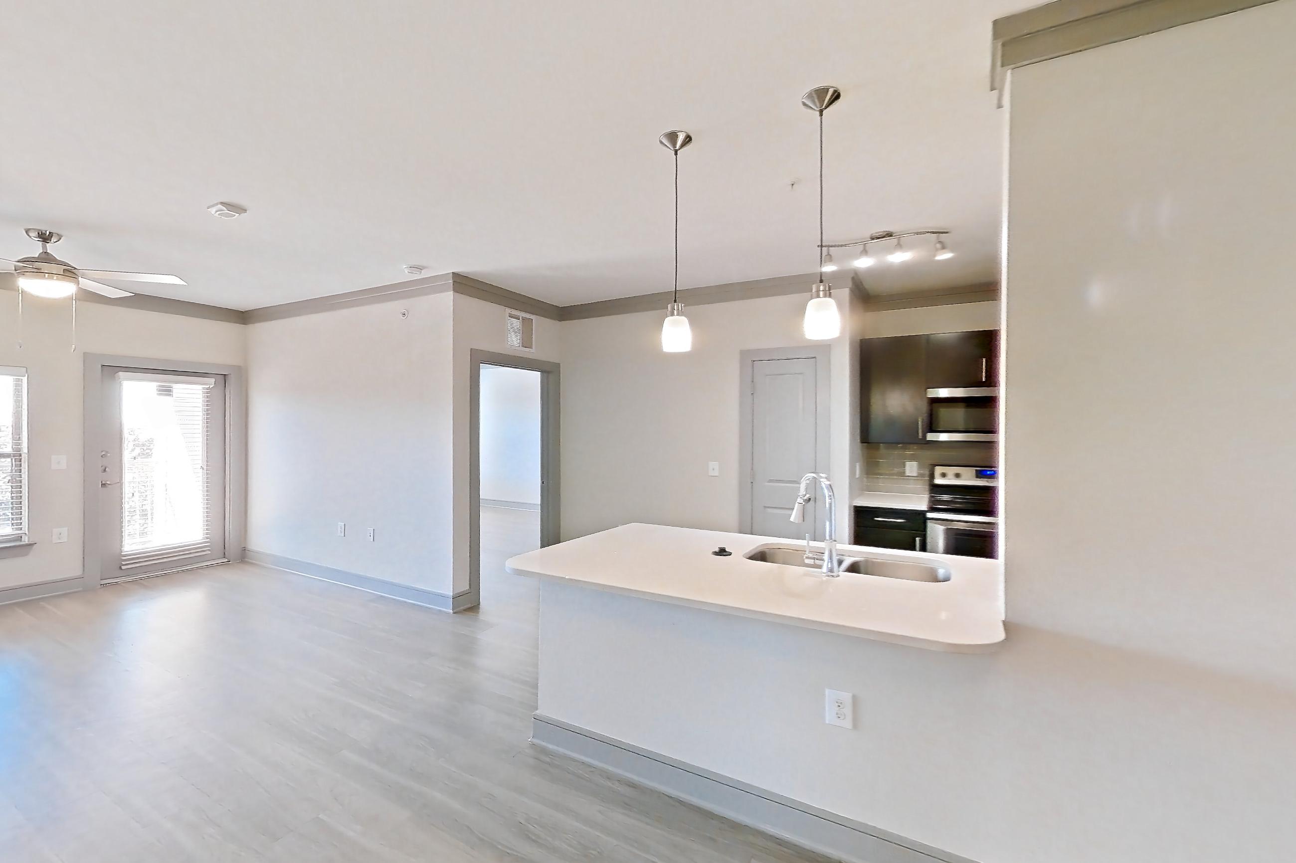 Dining room with light countertops, light wood-finish flooring, oven/range, and stainless steel appliances, Apartment 11302 at Cortland Phillips Creek Ranch
