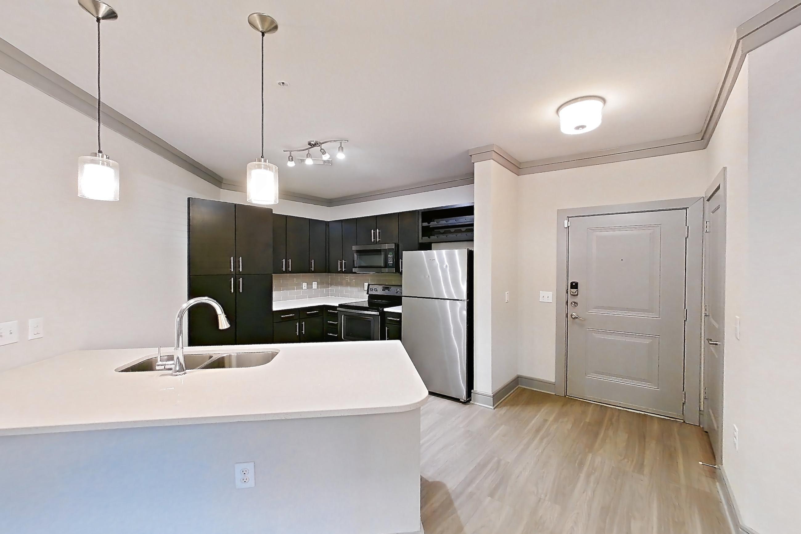 Dining room with electric range, light countertops, light wood-finish flooring, oven/range, refrigerator, and stainless steel appliances, Apartment 14106 at Cortland Phillips Creek Ranch