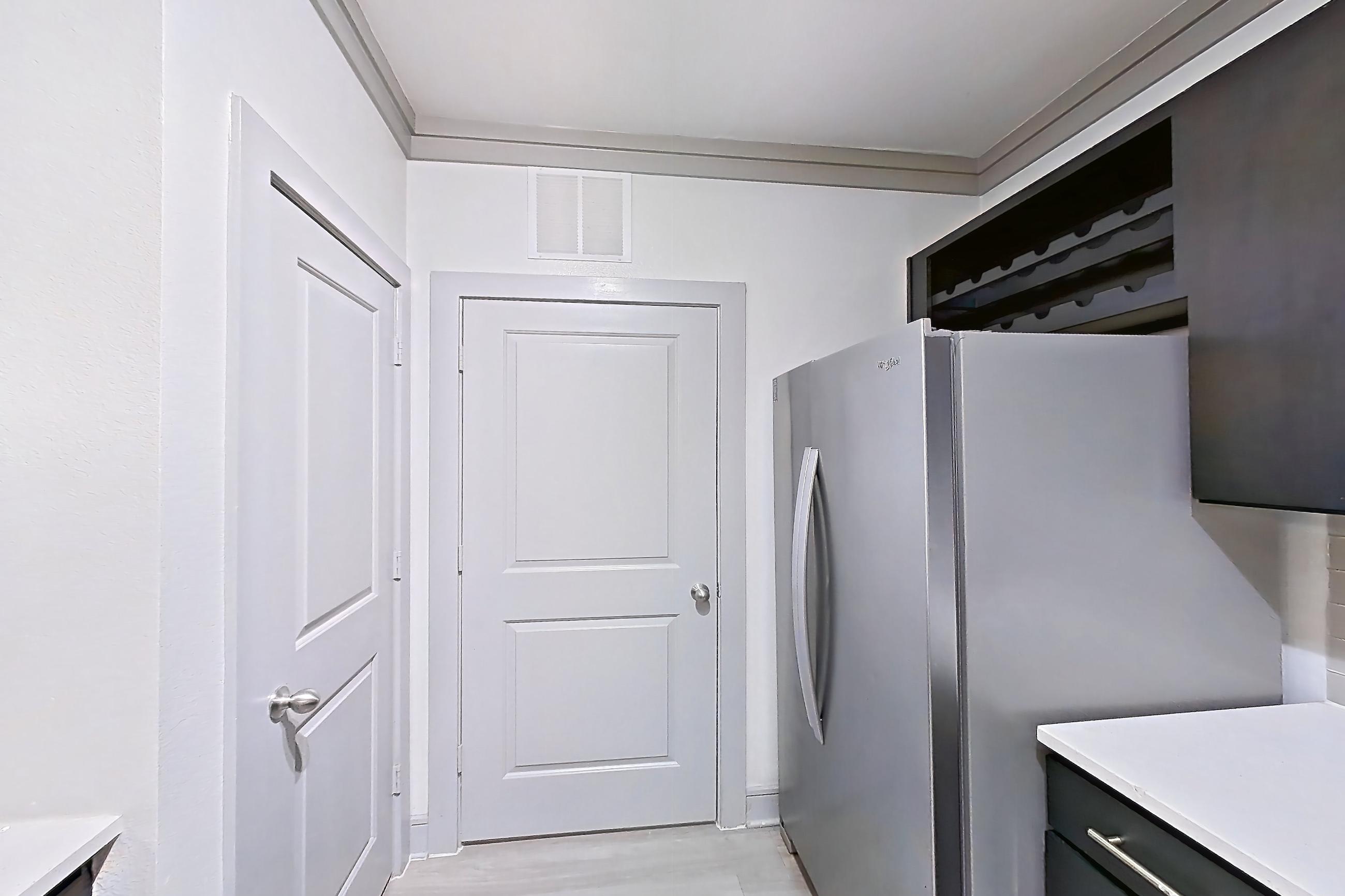 Kitchen with dishwasher, electric range, light countertops, light stone countertops, light wood-finish flooring, microwave, oven/range, and stainless steel appliances, Apartment 12207 at Cortland Phillips Creek Ranch