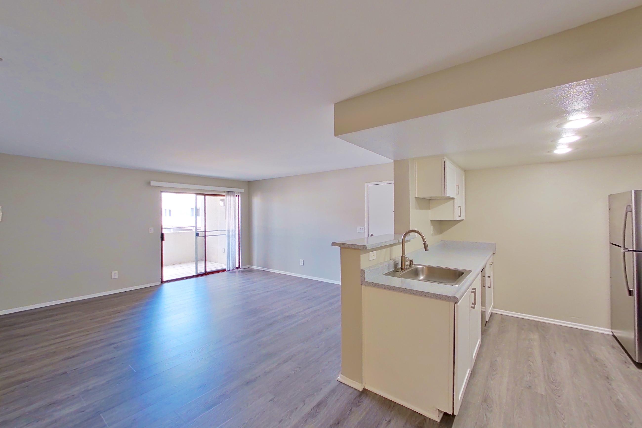 Dining area with electric range, light countertops, light wood-finish flooring, oven/range, refrigerator, and stainless steel appliances, Apartment 06 at Avana Rancho Cucamonga