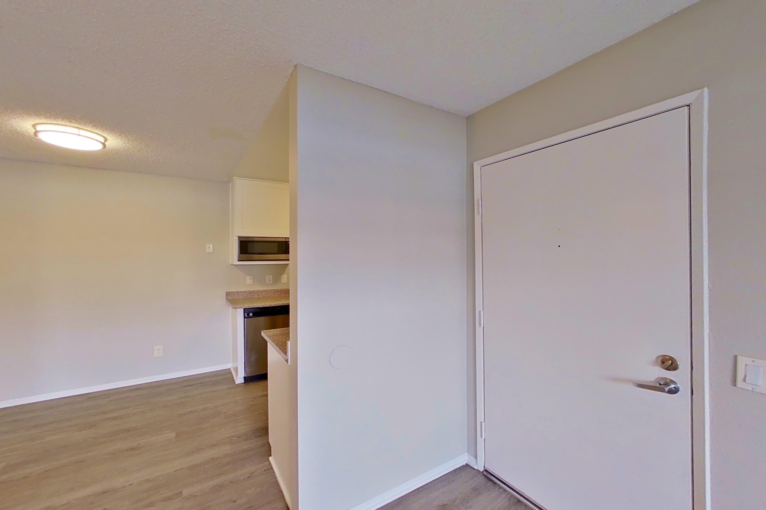 Living room with dishwasher and stainless steel appliances, Apartment 08-06 at Avana Rancho Cucamonga