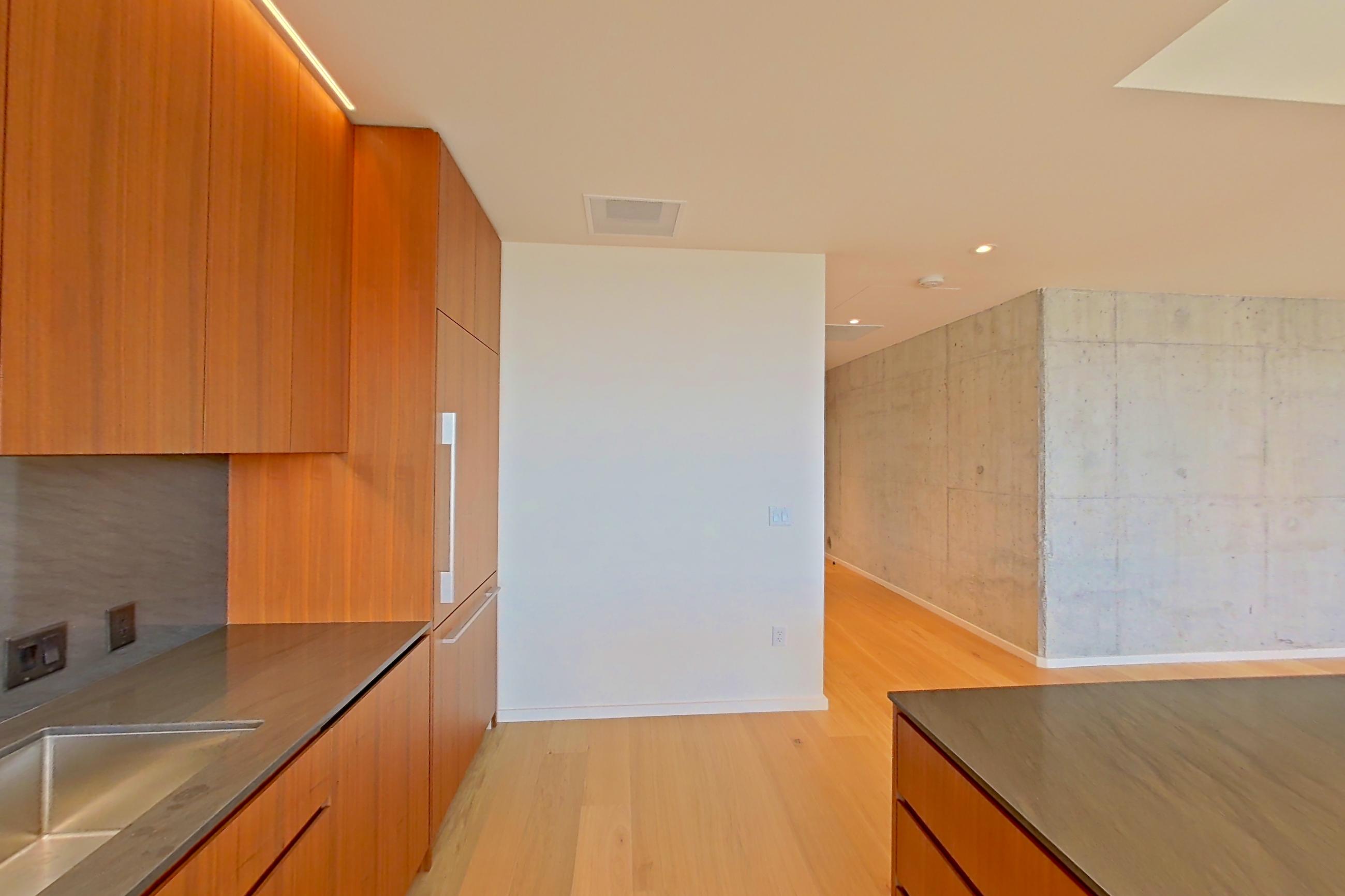 Kitchen with light wood-finish flooring, oven/range, and stainless steel appliances, Apartment 2404 at The Residences at 11W