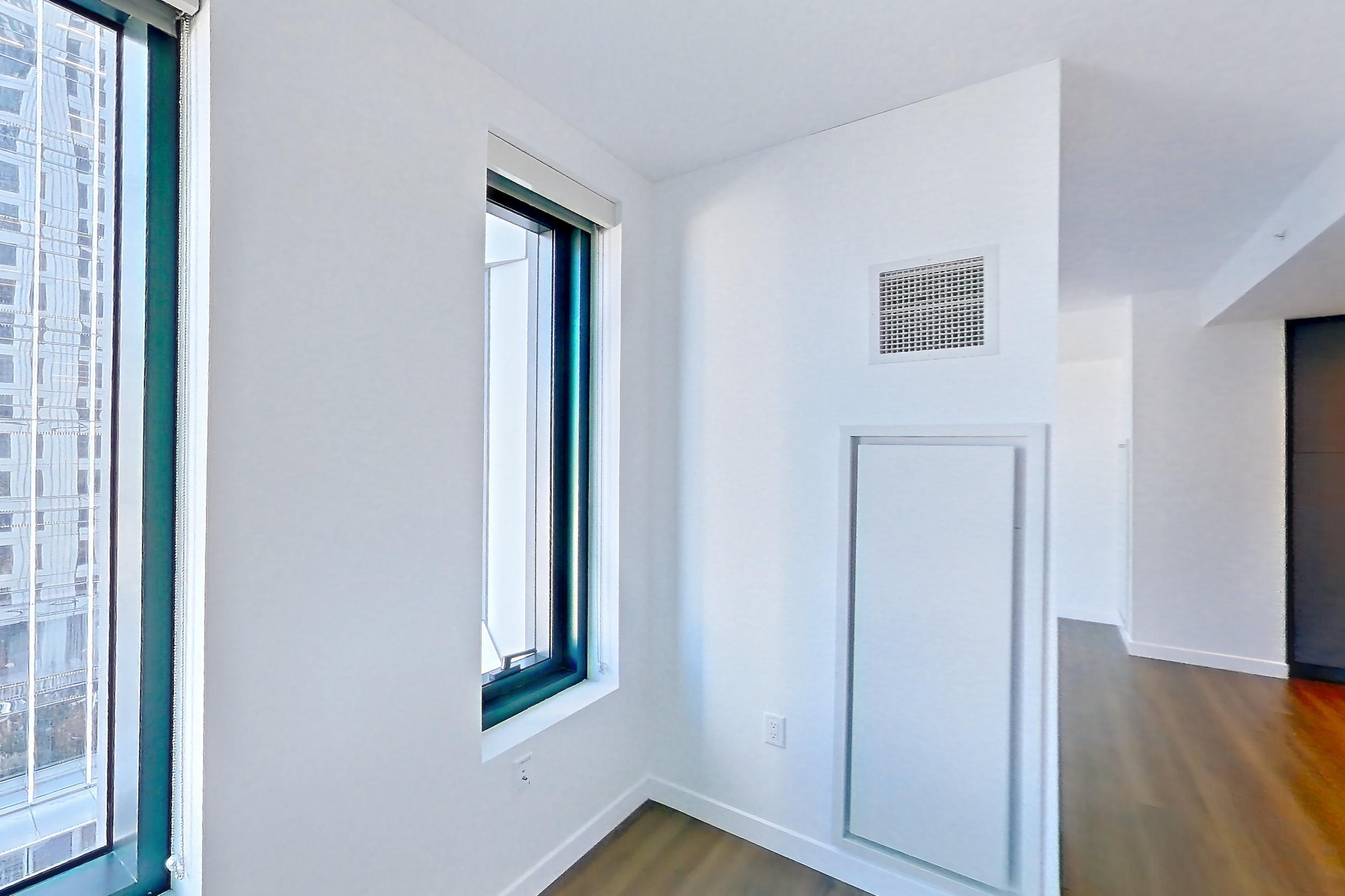 Living space with dark wood-finish flooring, electric range, oven/range, and stainless steel appliances, Apartment 1501 at The Sudbury