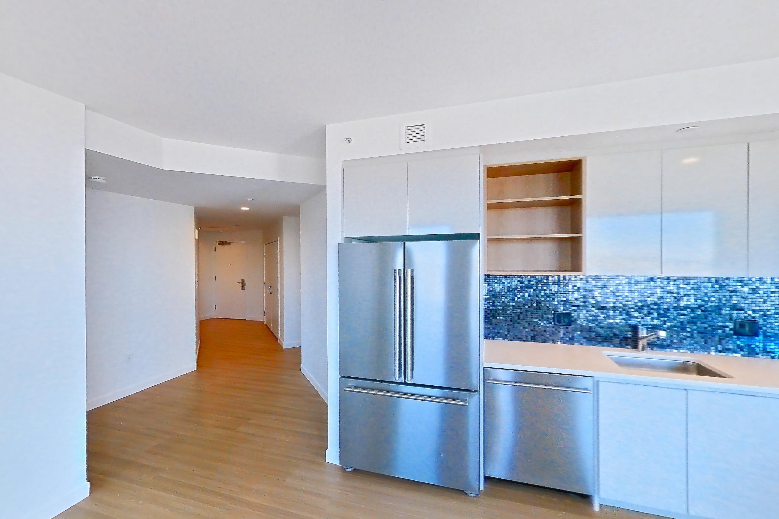 Living room with dishwasher, electric range, light stone countertops, light wood-finish flooring, oven/range, refrigerator, and stainless steel appliances, Apartment 2402 at The Sudbury