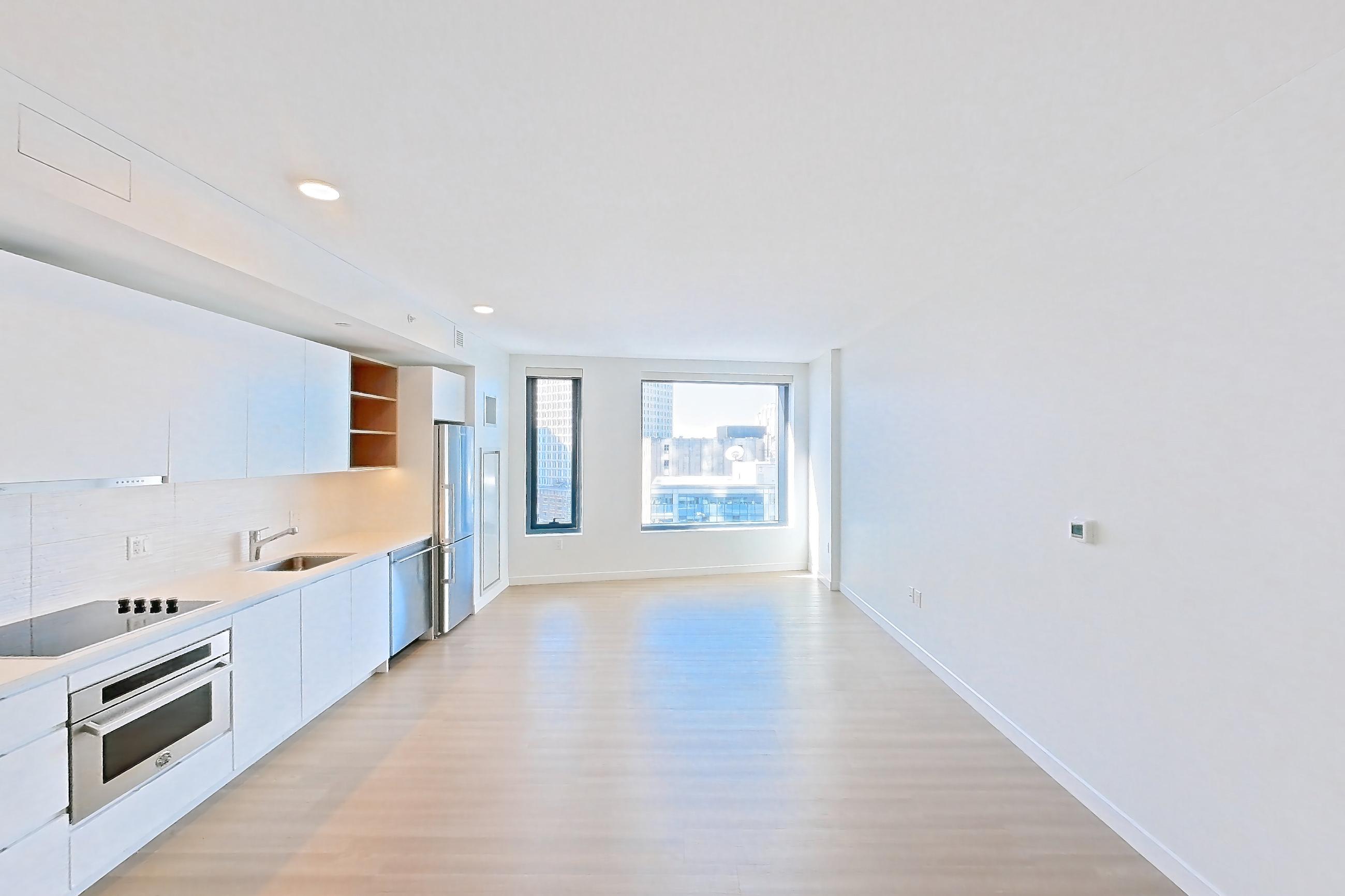 Living room with black appliances, cooktop, dishwasher, electric cooktop, light countertops, light wood-finish flooring, oven/range, and stainless steel appliances, Apartment 1114 at The Sudbury