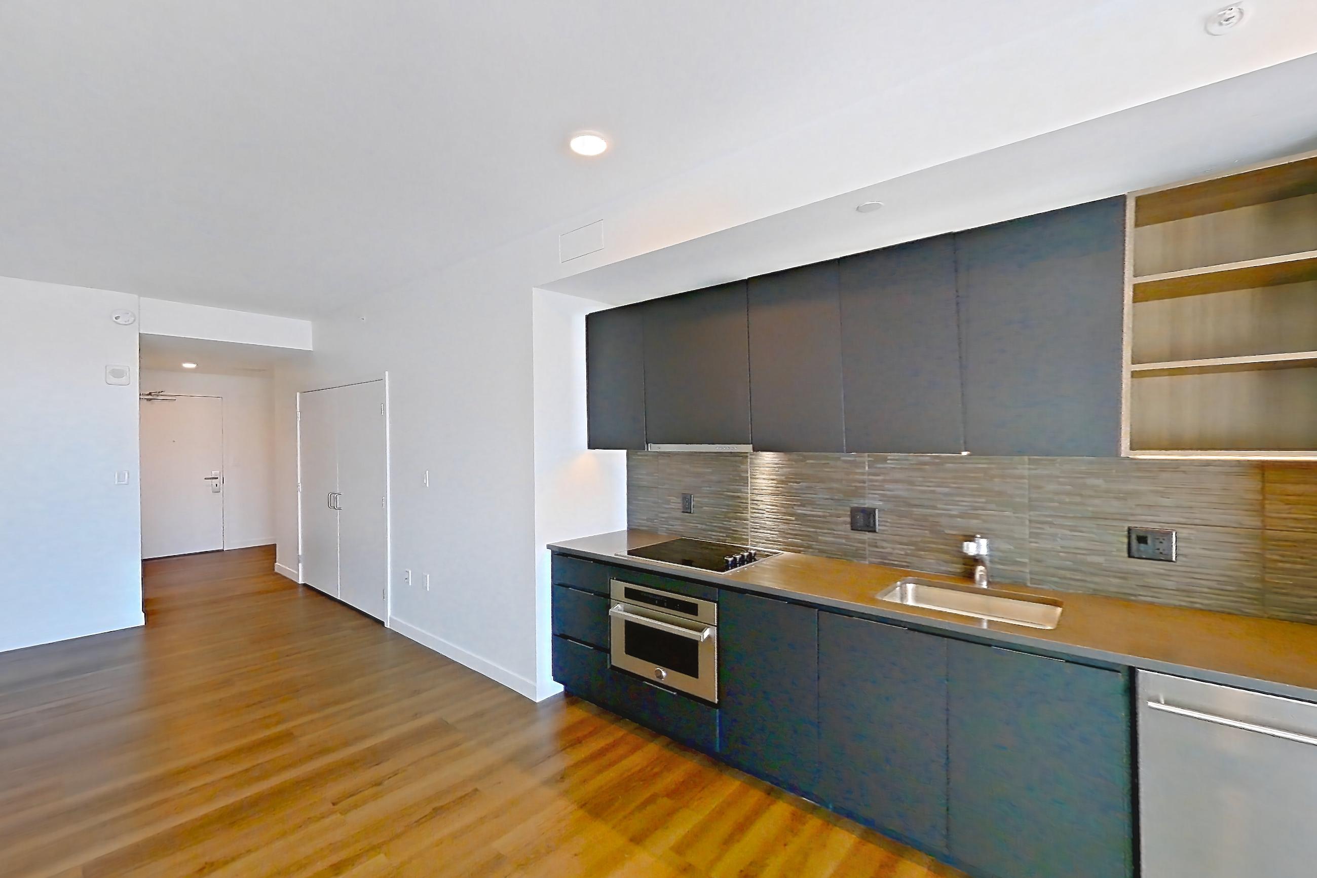 Living space 2 with black appliances, cooktop, dark countertops, dark wood-finish flooring, dishwasher, electric cooktop, oven/range, refrigerator, and stainless steel appliances, Apartment 1414 at The Sudbury