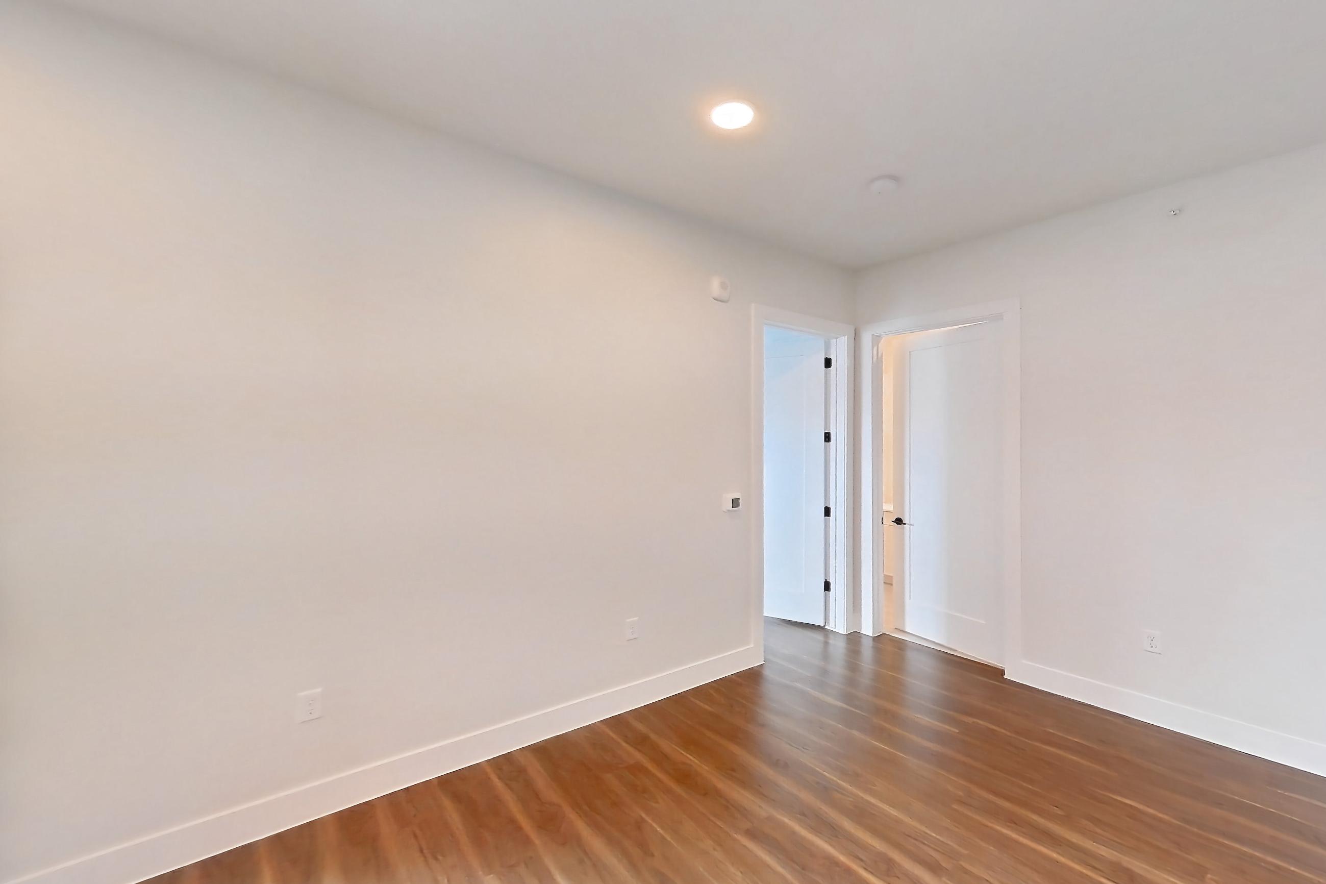 Living room with dark wood-finish flooring, dishwasher, electric range, light countertops, light wood-finish flooring, oven/range, refrigerator, and stainless steel appliances, Apartment 517 at Lantower West Love