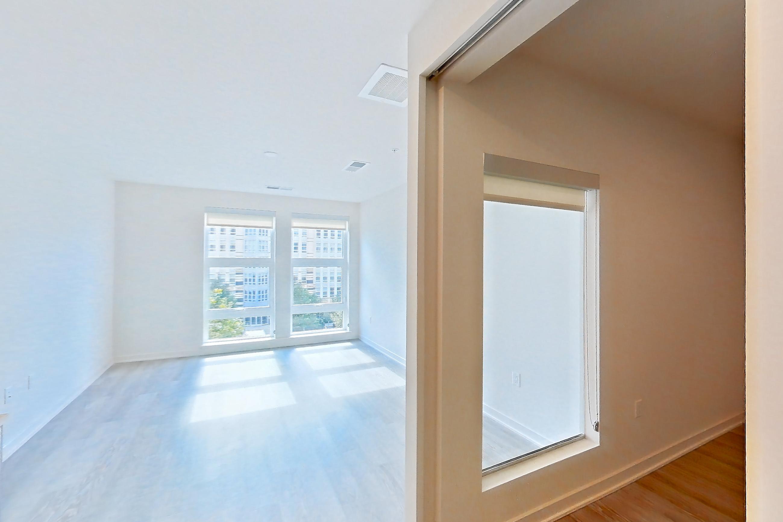 Kitchen with dishwasher, electric range, light countertops, light stone countertops, light wood-finish flooring, microwave, oven/range, refrigerator, and stainless steel appliances, Apartment 3421 at Platform (VA)