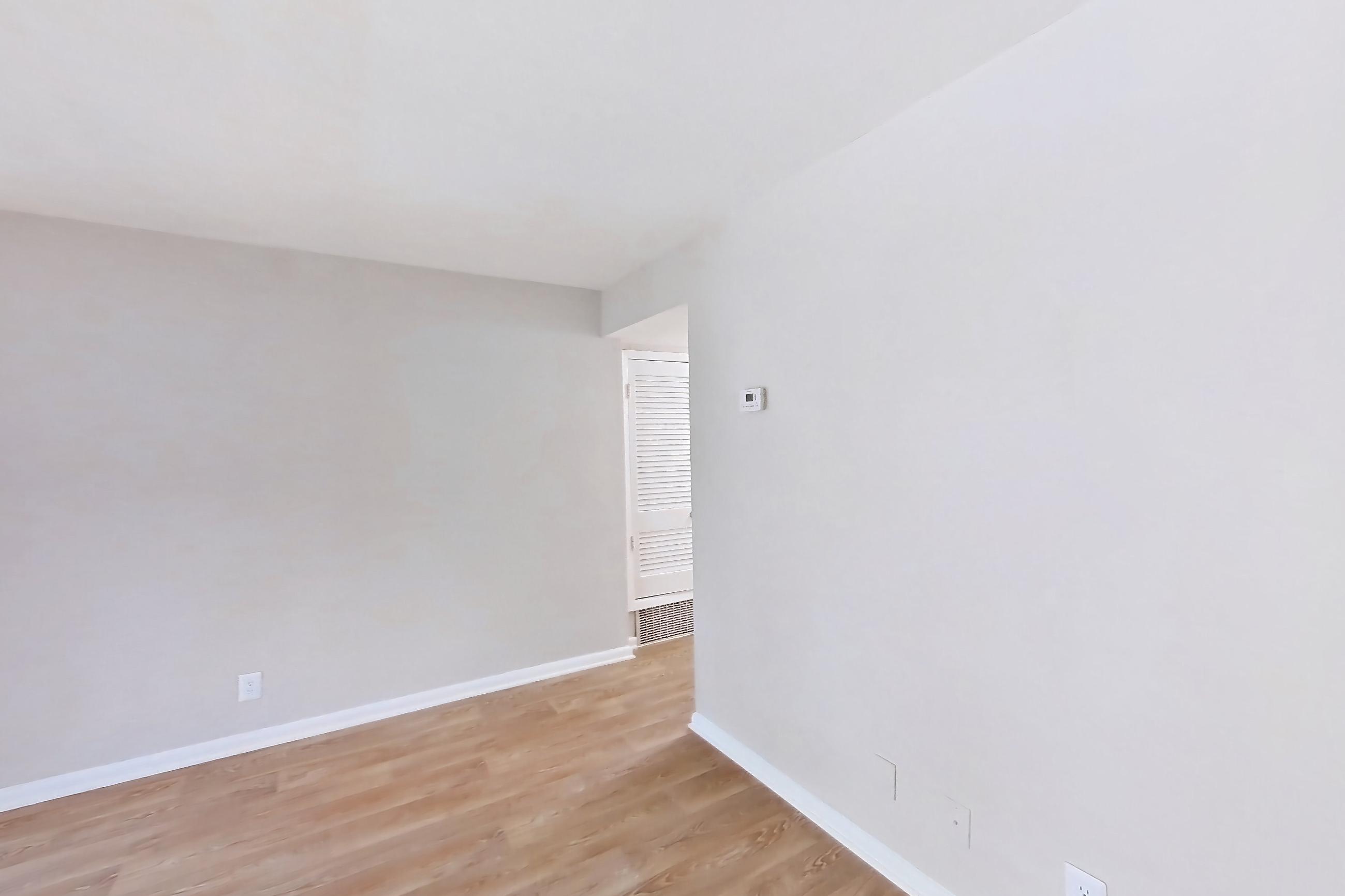 Living room with light wood-finish flooring, Apartment H1544D at The Legacy at Druid Hills