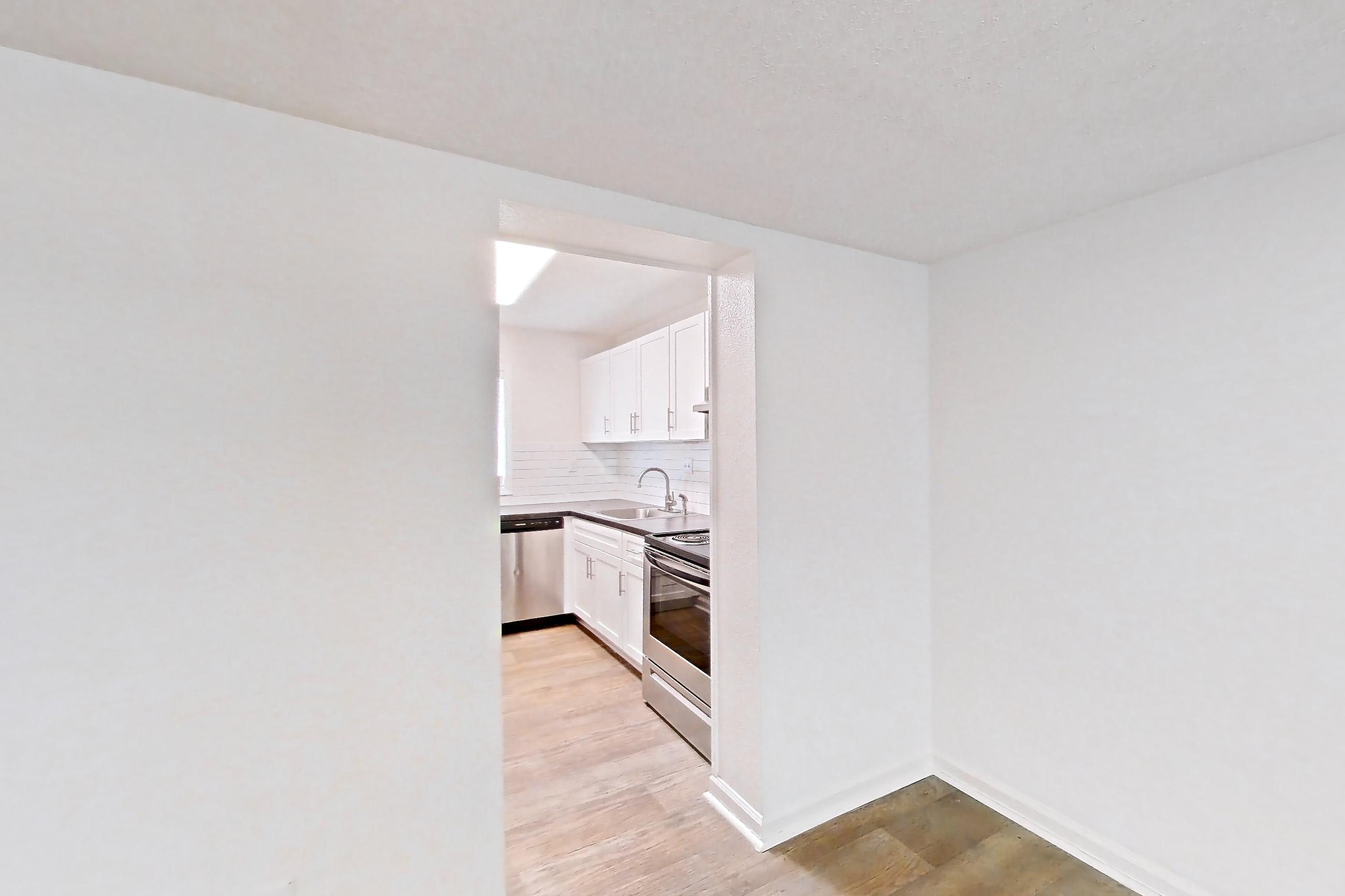 Dining room with dishwasher, electric range, light wood-finish flooring, oven/range, and stainless steel appliances, Apartment L1452T at The Legacy at Druid Hills