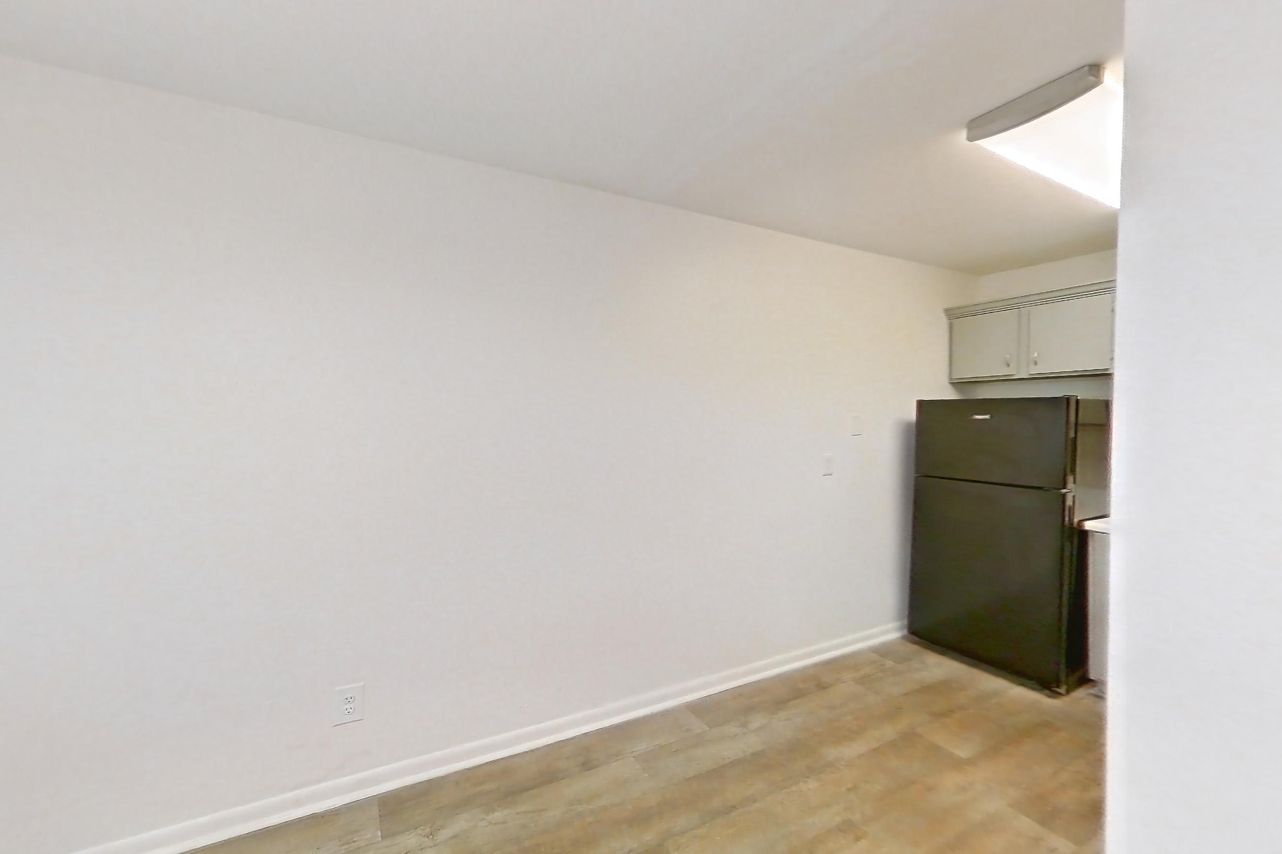 Dining room with black appliances, light wood-finish flooring, and refrigerator, Apartment L1471F at The Legacy at Druid Hills