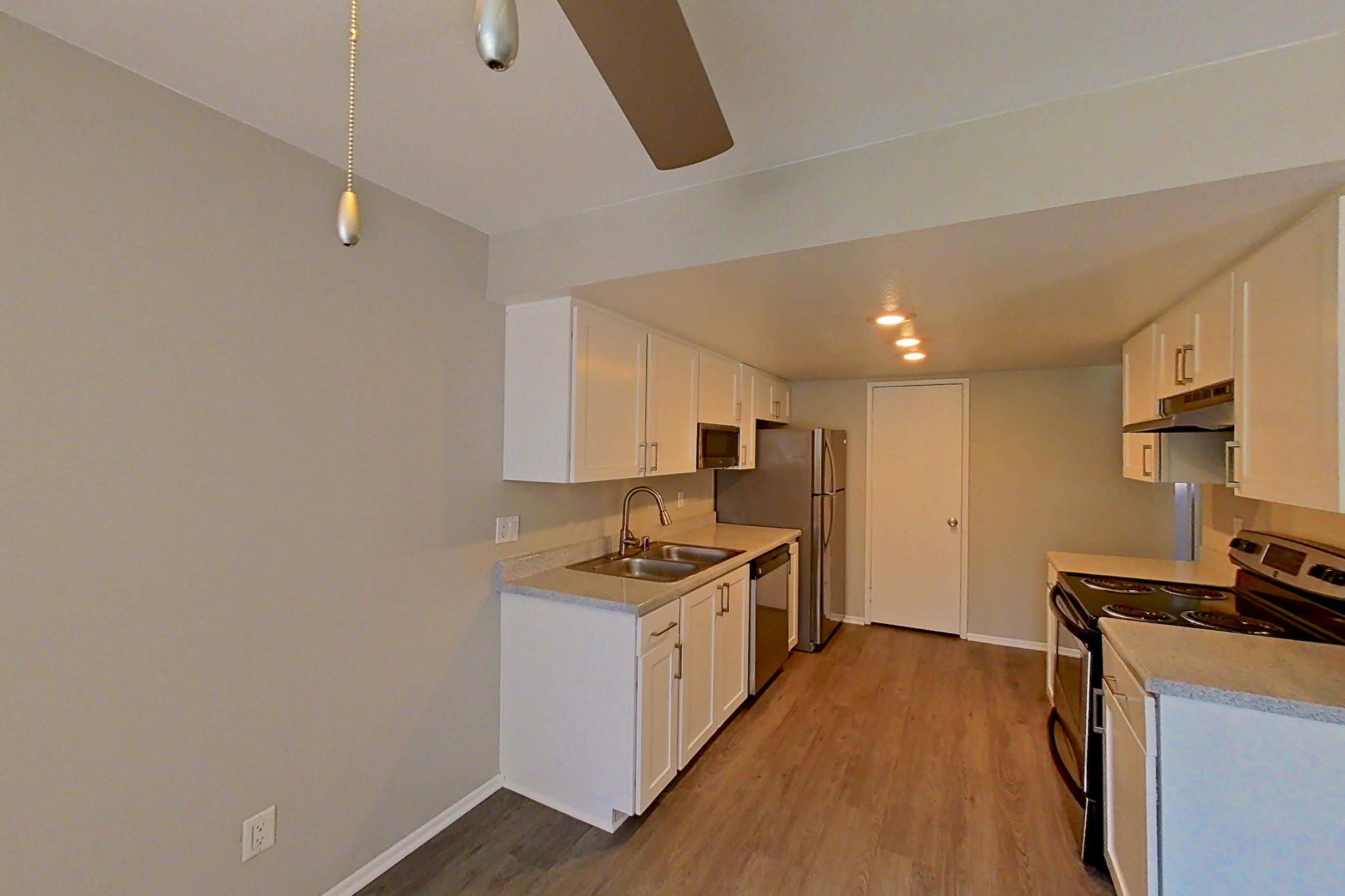 Dining area with dishwasher, electric range, light countertops, oven/range, refrigerator, stainless steel appliances, and white appliances, Apartment 09 at Avana Rancho Cucamonga