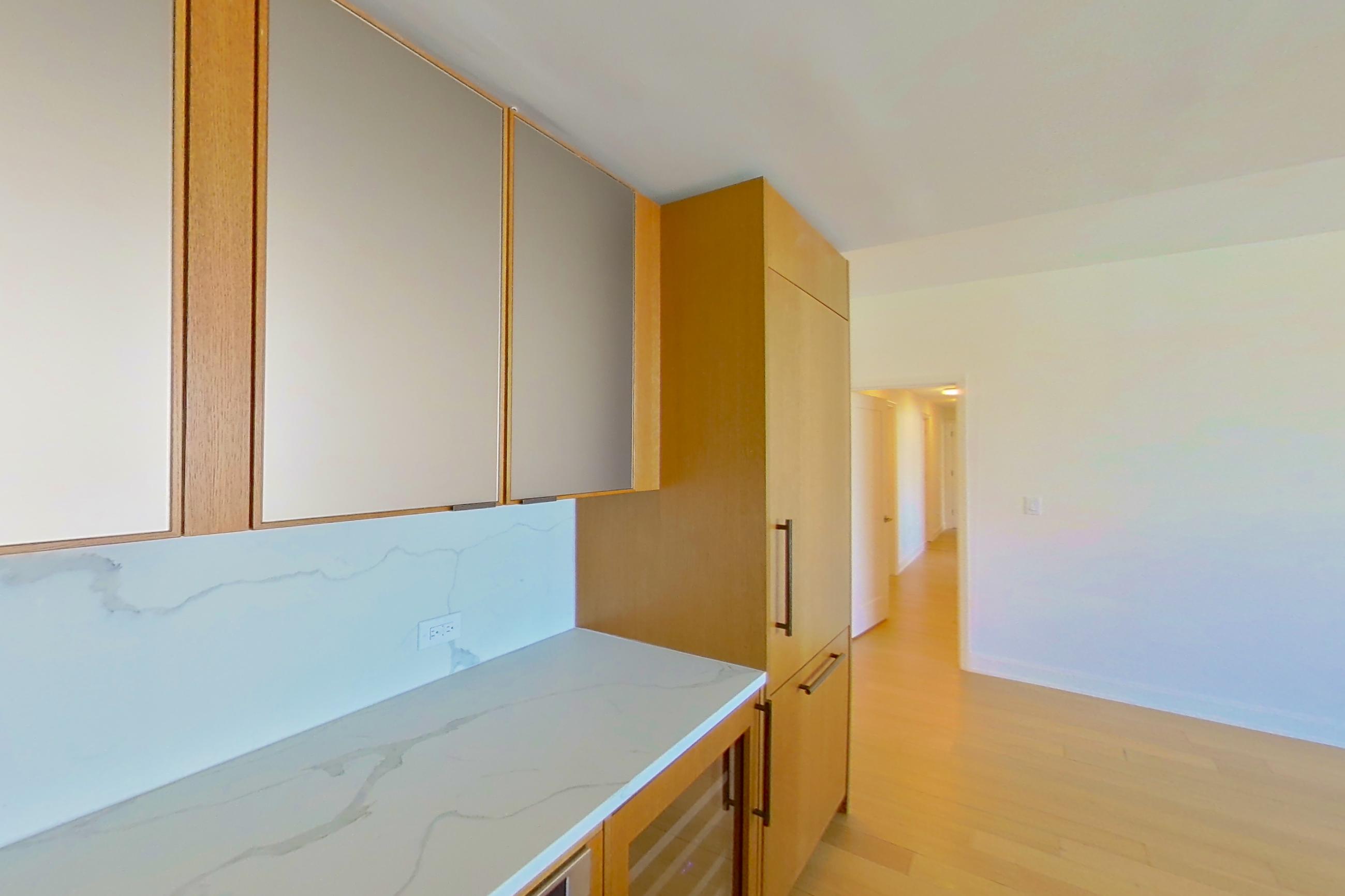 Kitchen with black appliances, cooktop, electric cooktop, light stone countertops, light wood-finish flooring, oven/range, and stainless steel appliances, Apartment 3805 at Oriana