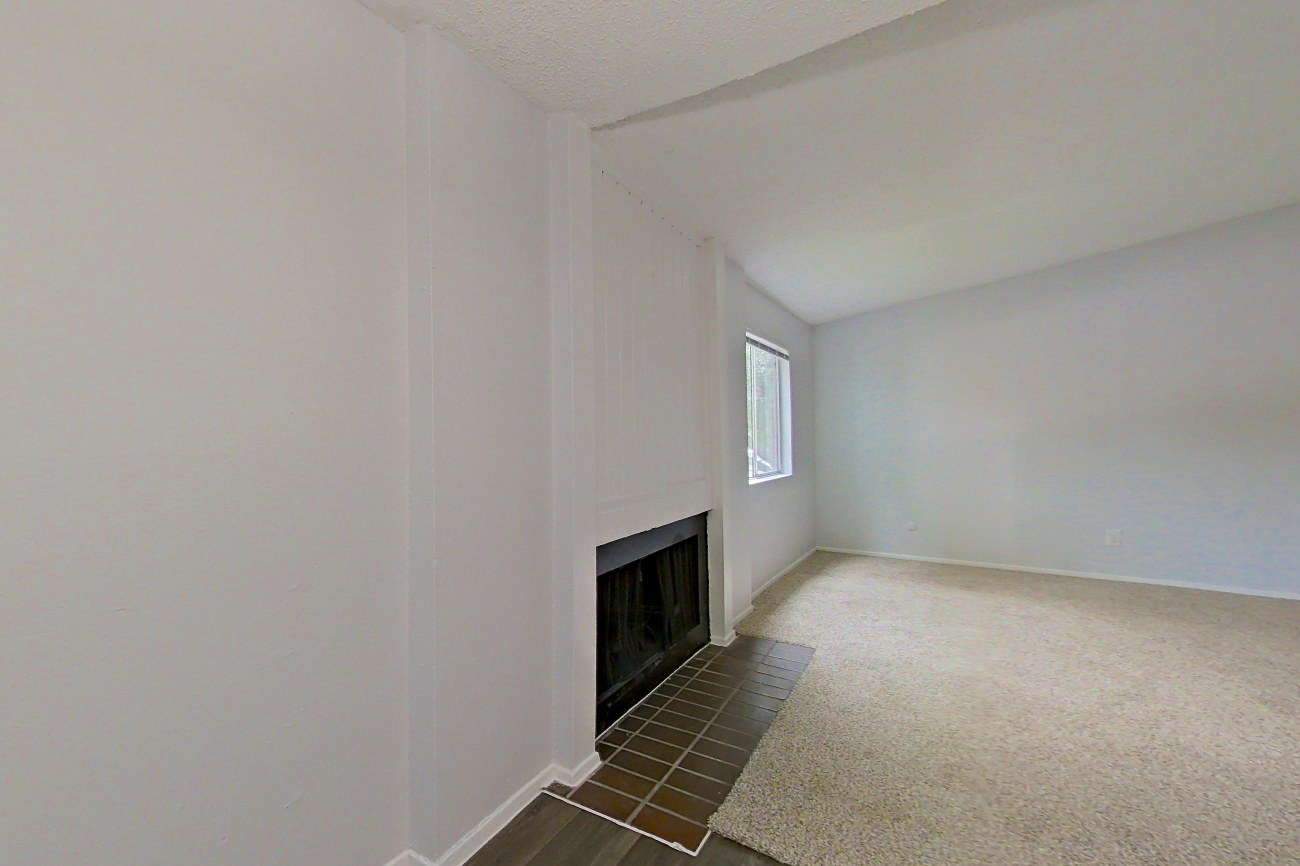 Living space with dark wood-finish flooring, fireplace, refrigerator, and stainless steel appliances, Apartment 1904 at The Cove Apartments