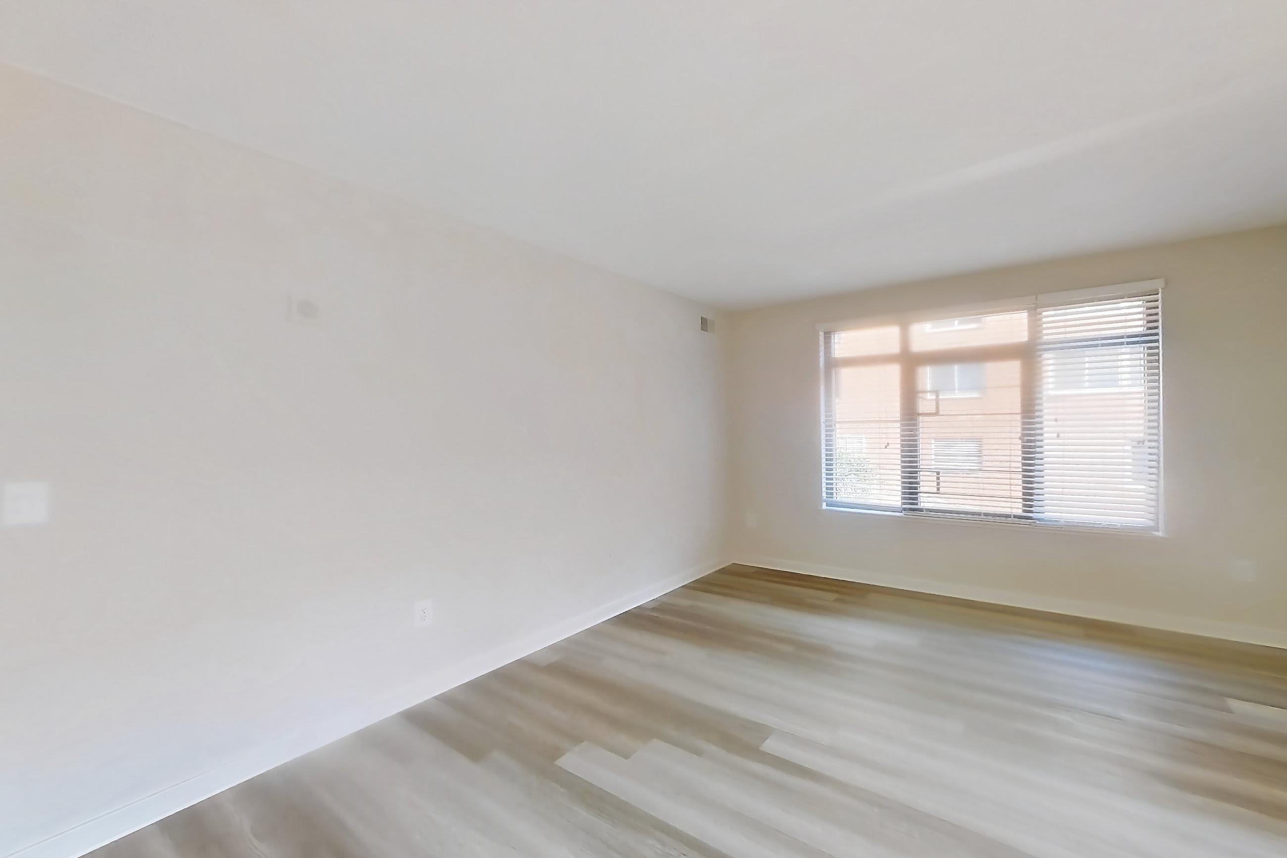 Kitchen with dark stone countertops and light wood-finish flooring, Apartment 302 at The Barton at Woodley