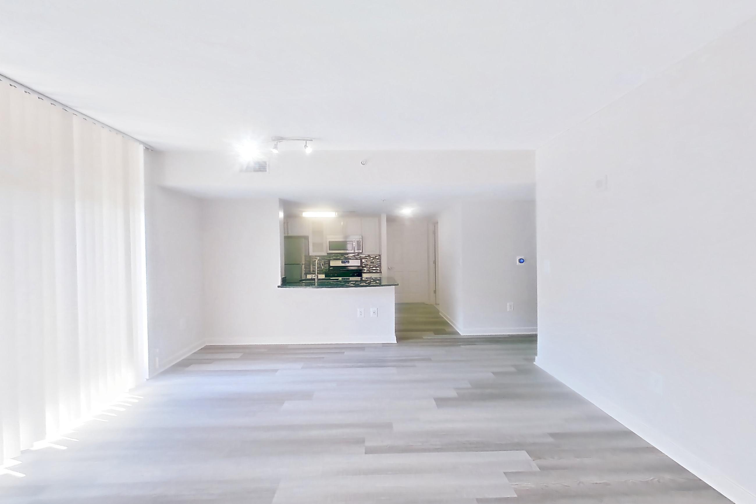 Living space with light wood-finish flooring, Apartment 302 at The Barton at Woodley
