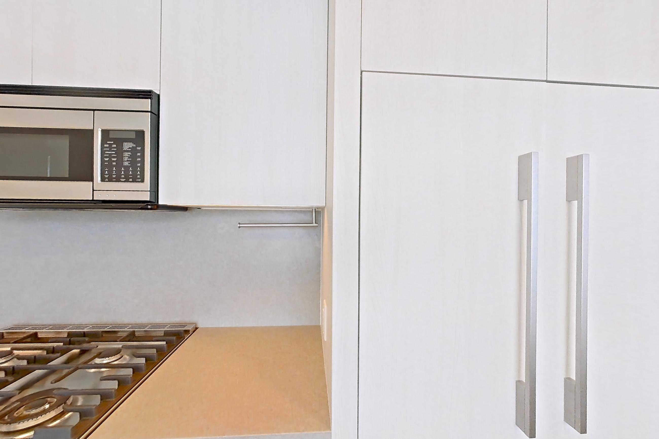 Kitchen with gas range, light countertops, light stone countertops, light wood-finish flooring, microwave, oven/range, and stainless steel appliances, Apartment 3213 at Alloy