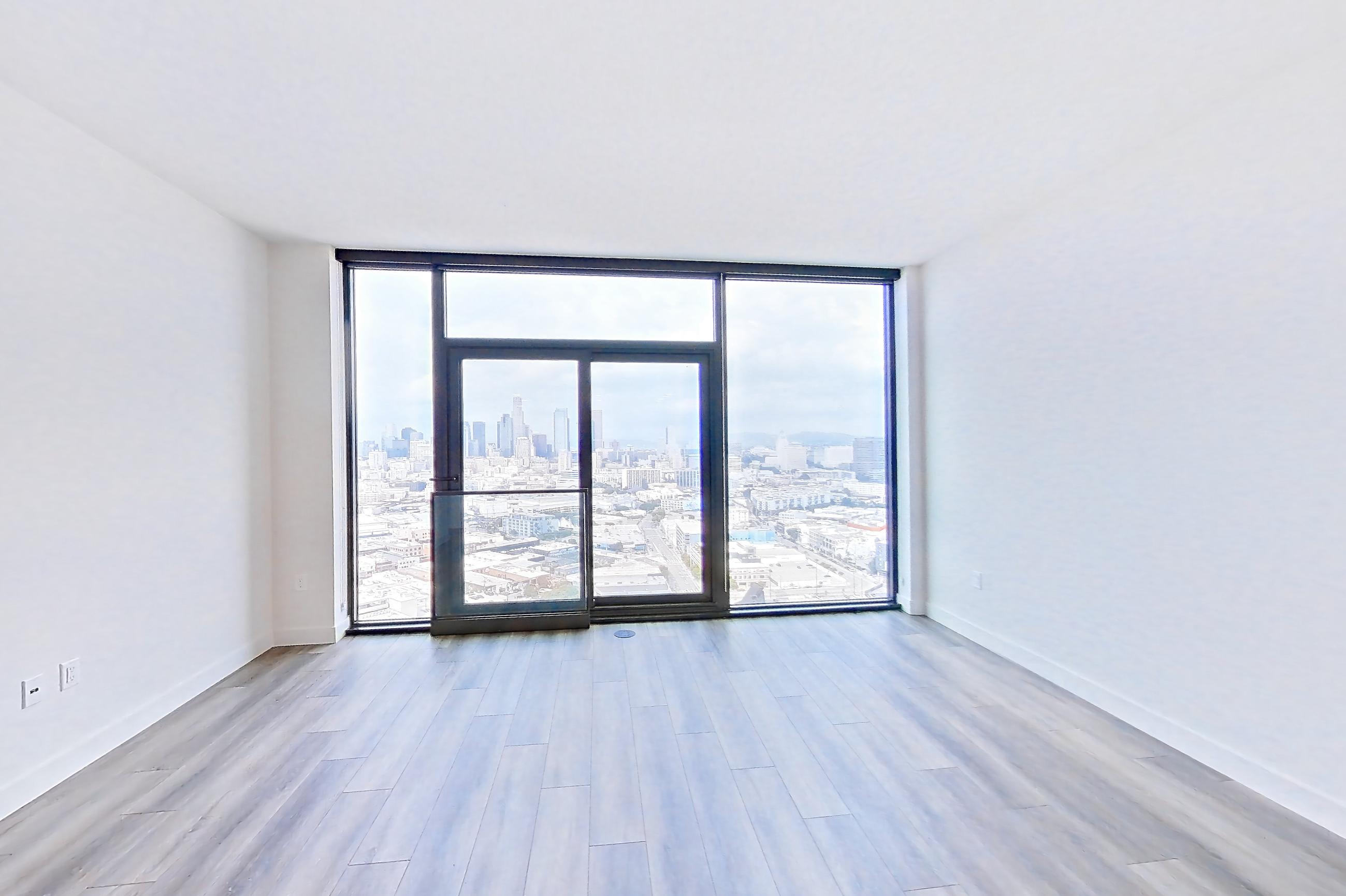 Living room with city view, dark wood-finish flooring, gas range, oven/range, and stainless steel appliances, Apartment 3213 at Alloy