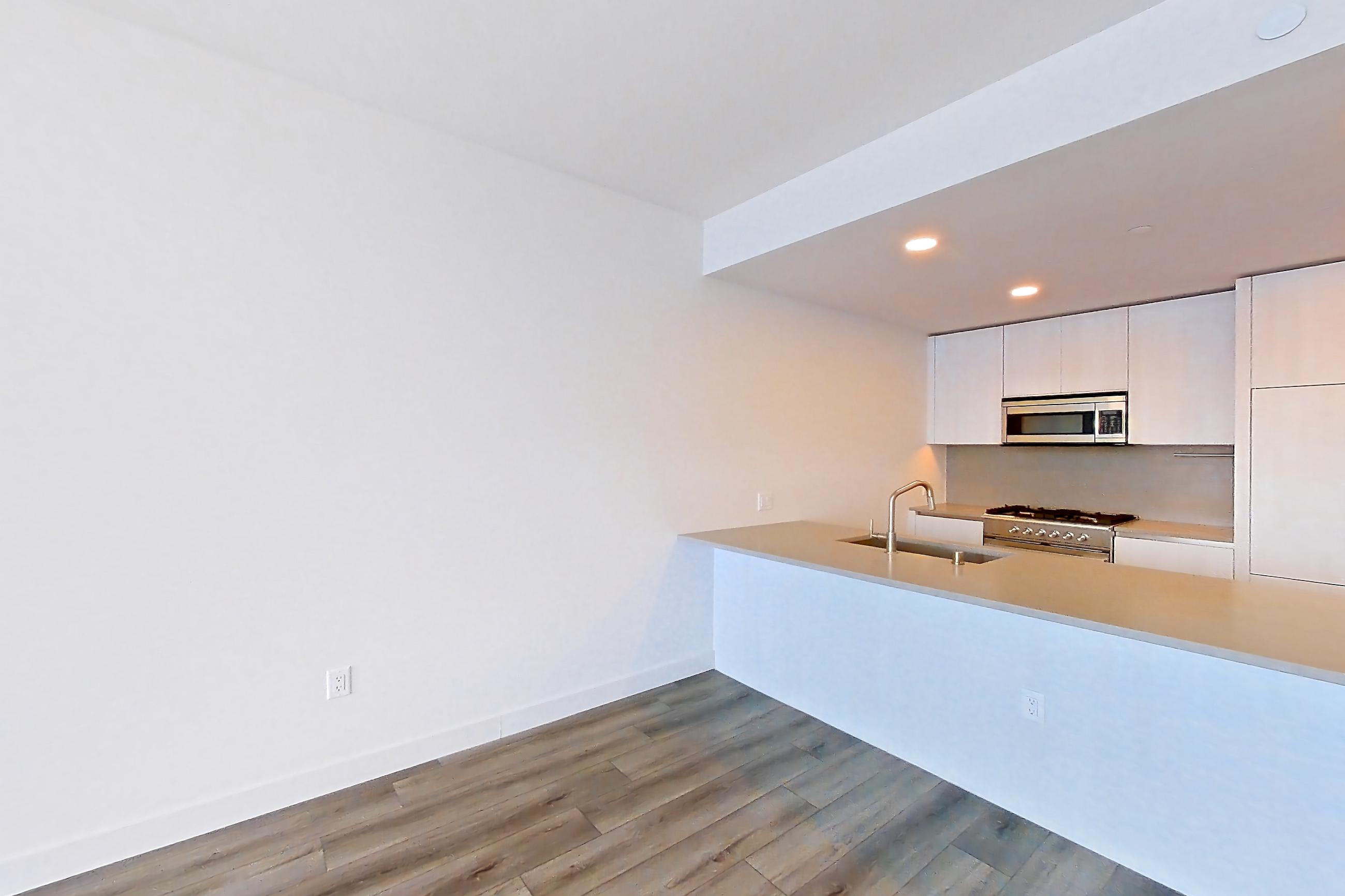 Living room with city view, dark wood-finish flooring, gas range, oven/range, and stainless steel appliances, Apartment 3213 at Alloy