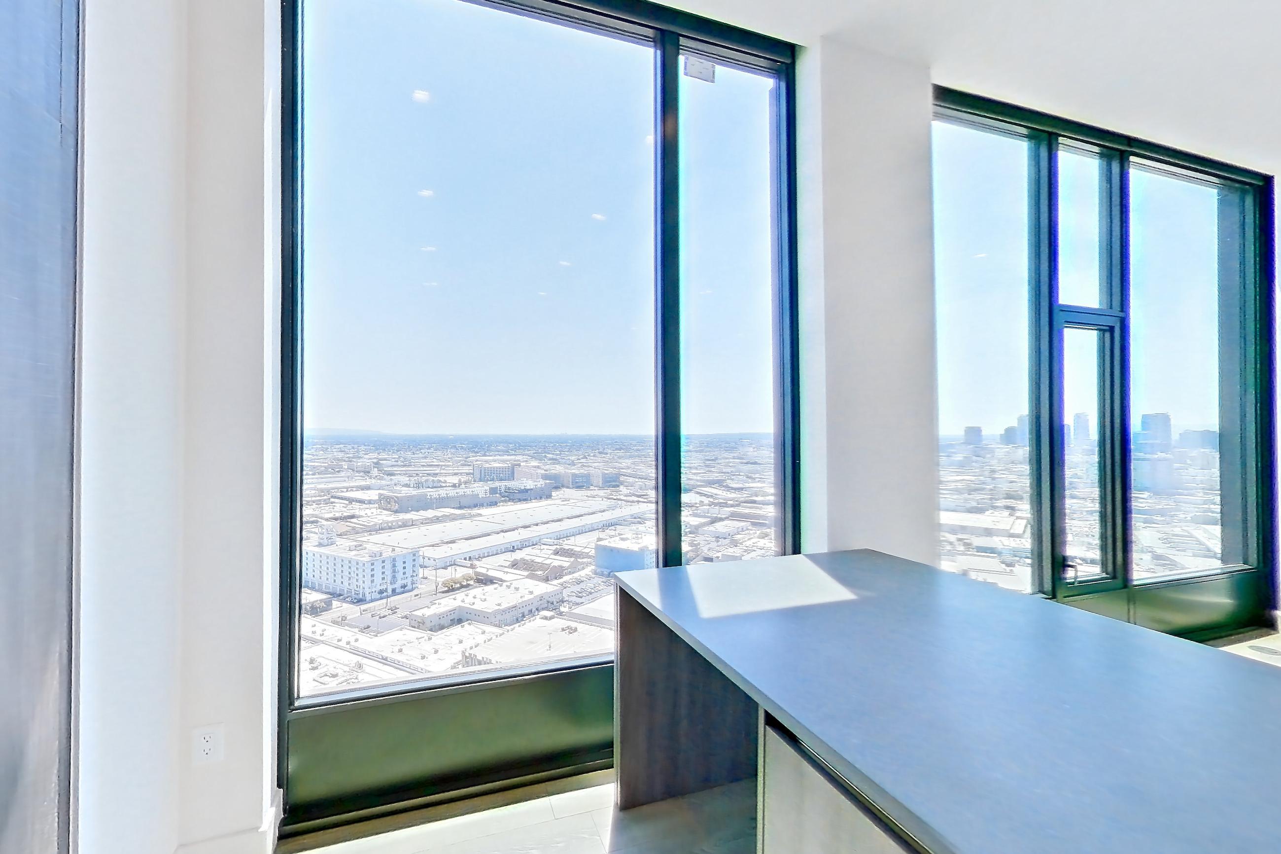 Kitchen with black appliances, city view, gas cooktop, oven/range, and range hood, Apartment PH01 at Alloy