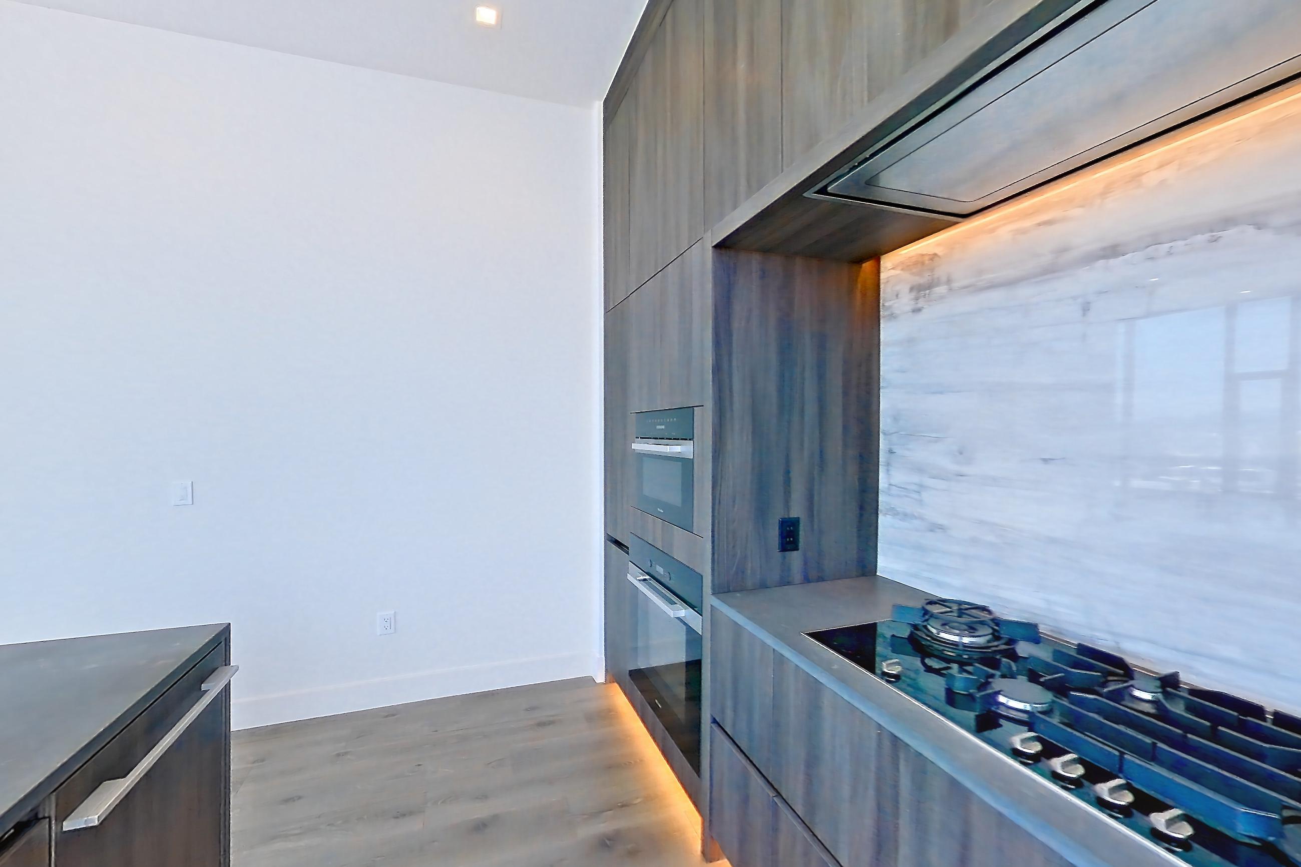 Kitchen with black appliances, city view, gas cooktop, oven/range, and range hood, Apartment PH01 at Alloy