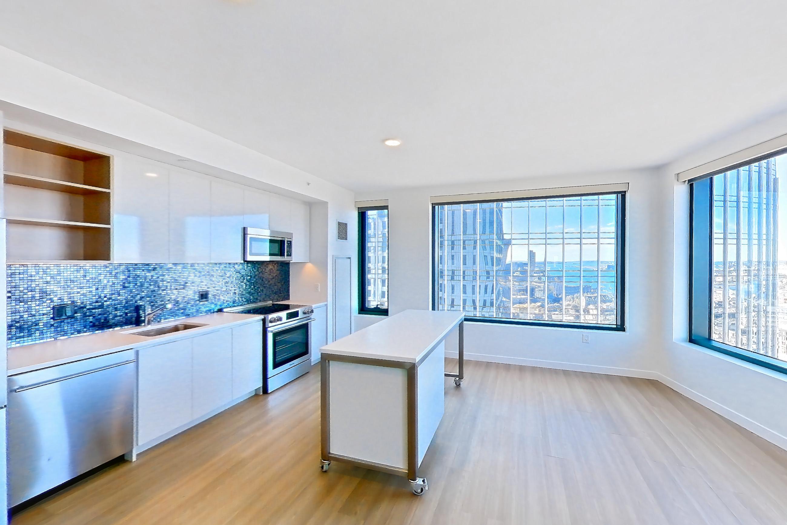 Living room 1 with dishwasher, electric range, light countertops, light wood-finish flooring, oven/range, refrigerator, and stainless steel appliances, Apartment 2802 at The Sudbury
