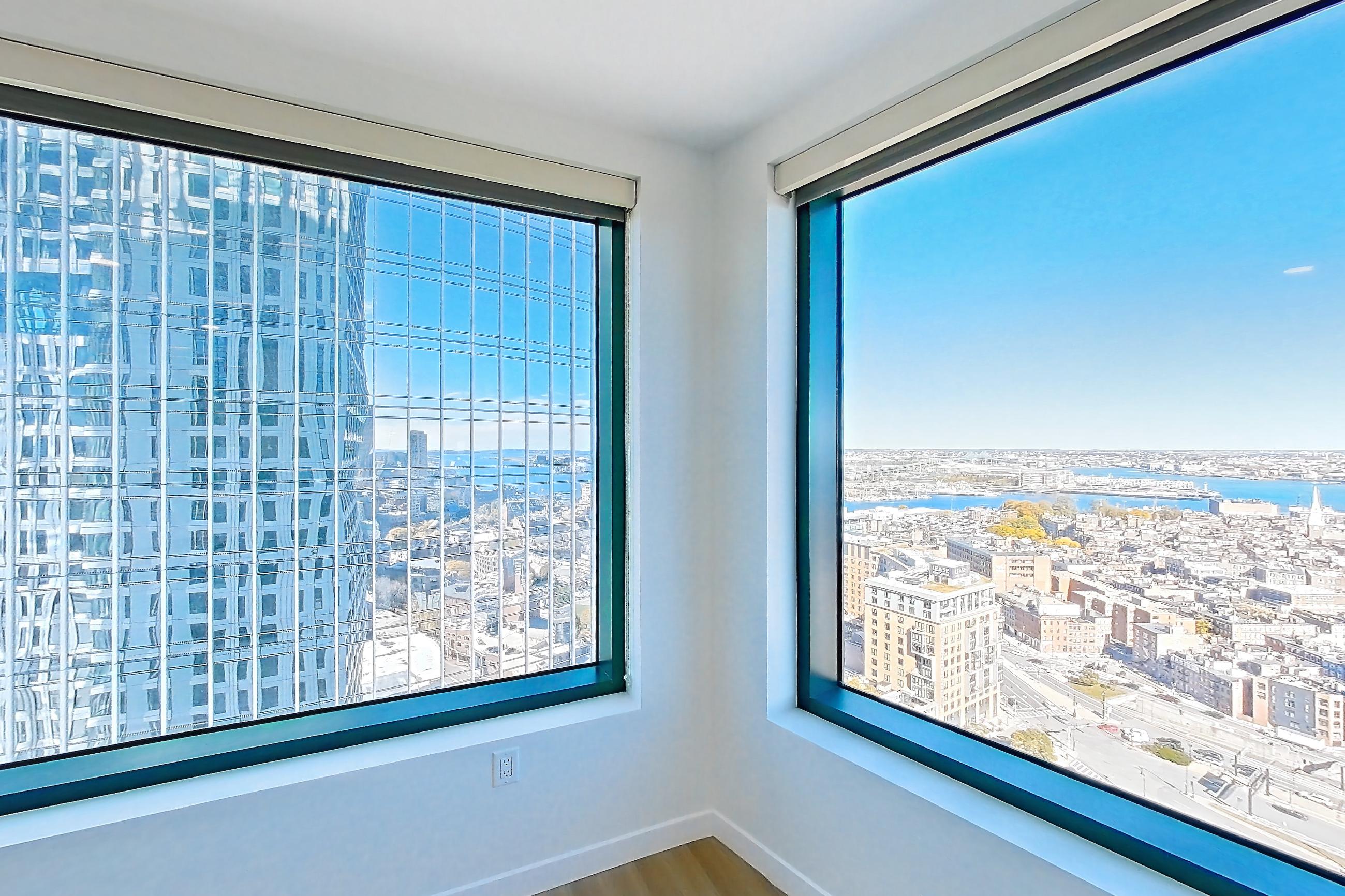 Living room 2 with city view, electric range, light countertops, light wood-finish flooring, oven/range, stainless steel appliances, and water view, Apartment 2802 at The Sudbury