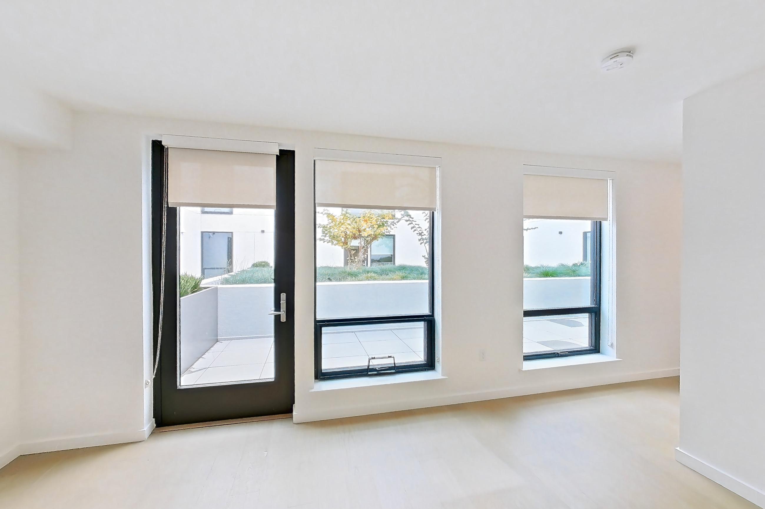Living space with light wood-finish flooring, Apartment 205 at Akin Residences