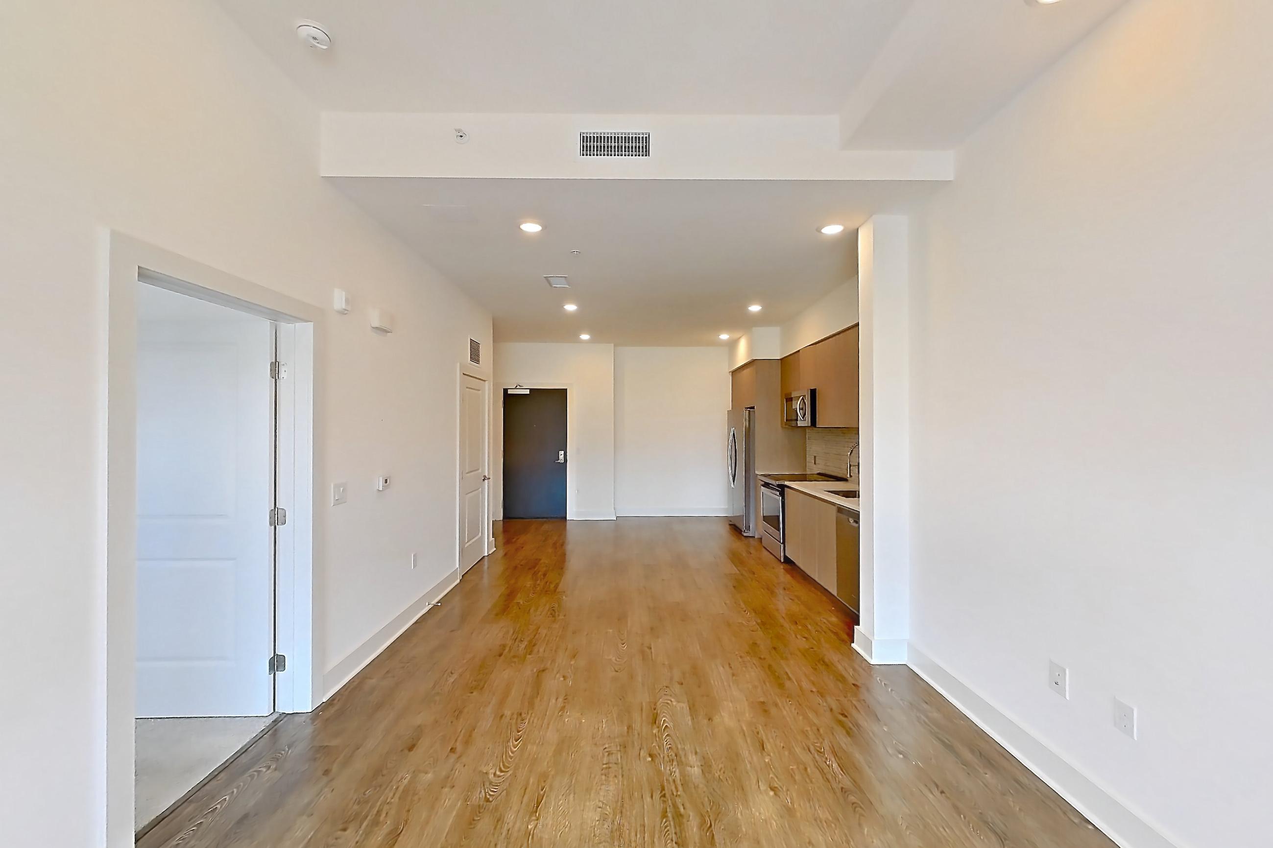 Living room with dark wood-finish flooring, electric range, oven/range, and stainless steel appliances, Apartment 205 at Diridon West