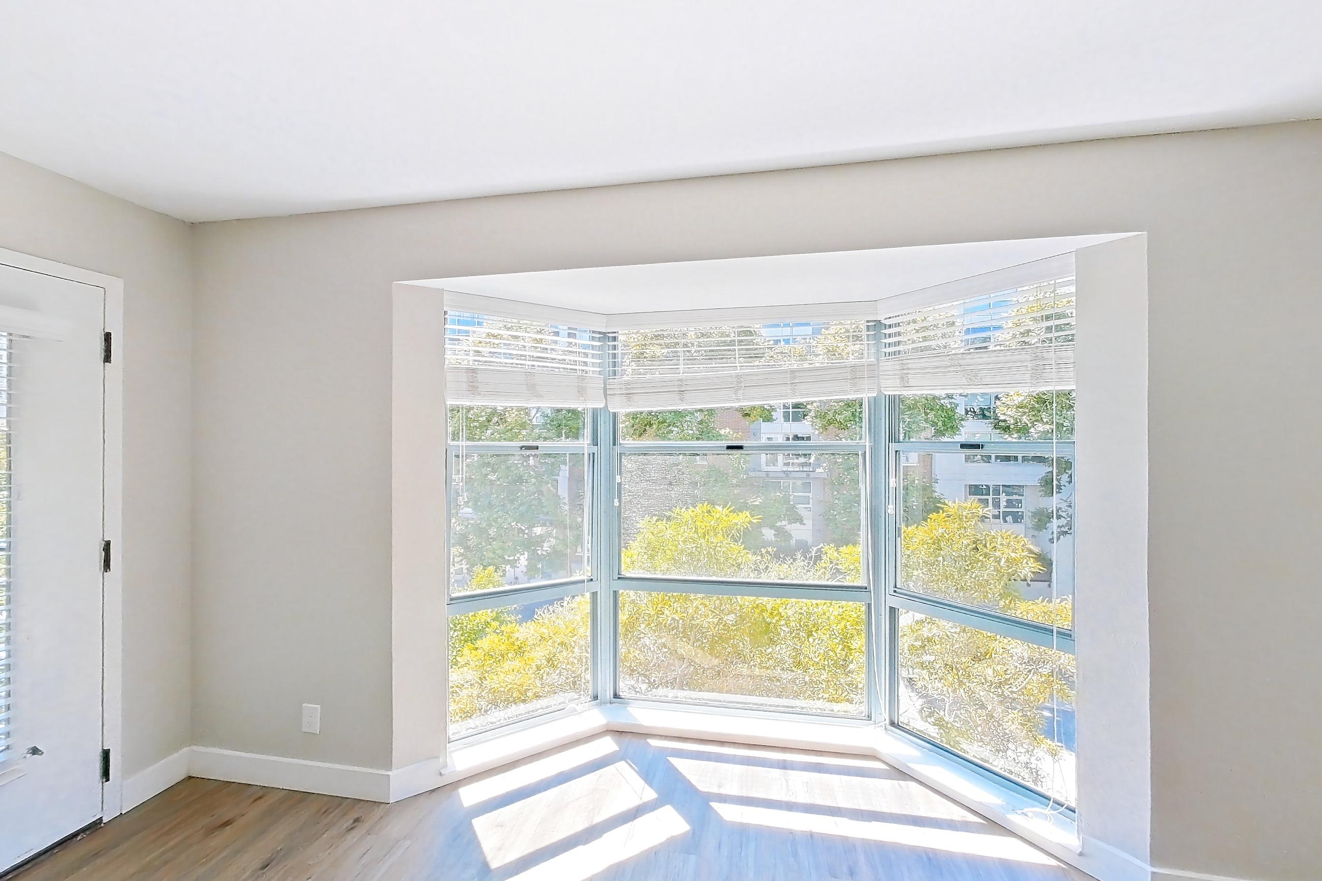 Living room with baseboard heating and light wood-finish flooring, Apartment 1-319 at Bayside Village
