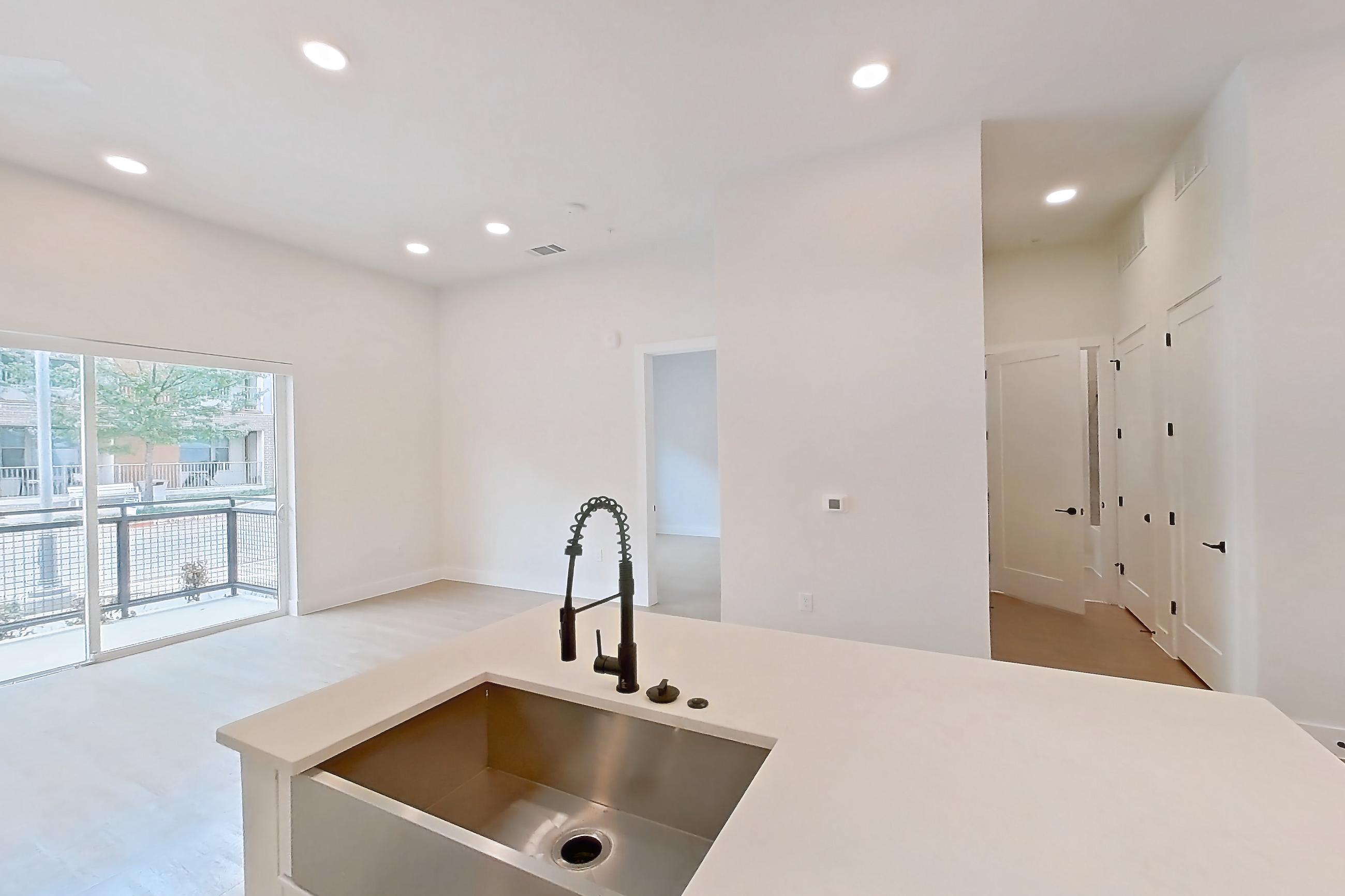 Kitchen with dishwasher, kitchen island, light countertops, light wood-finish flooring, refrigerator, and stainless steel appliances, Apartment 120 at Lantower Midtown
