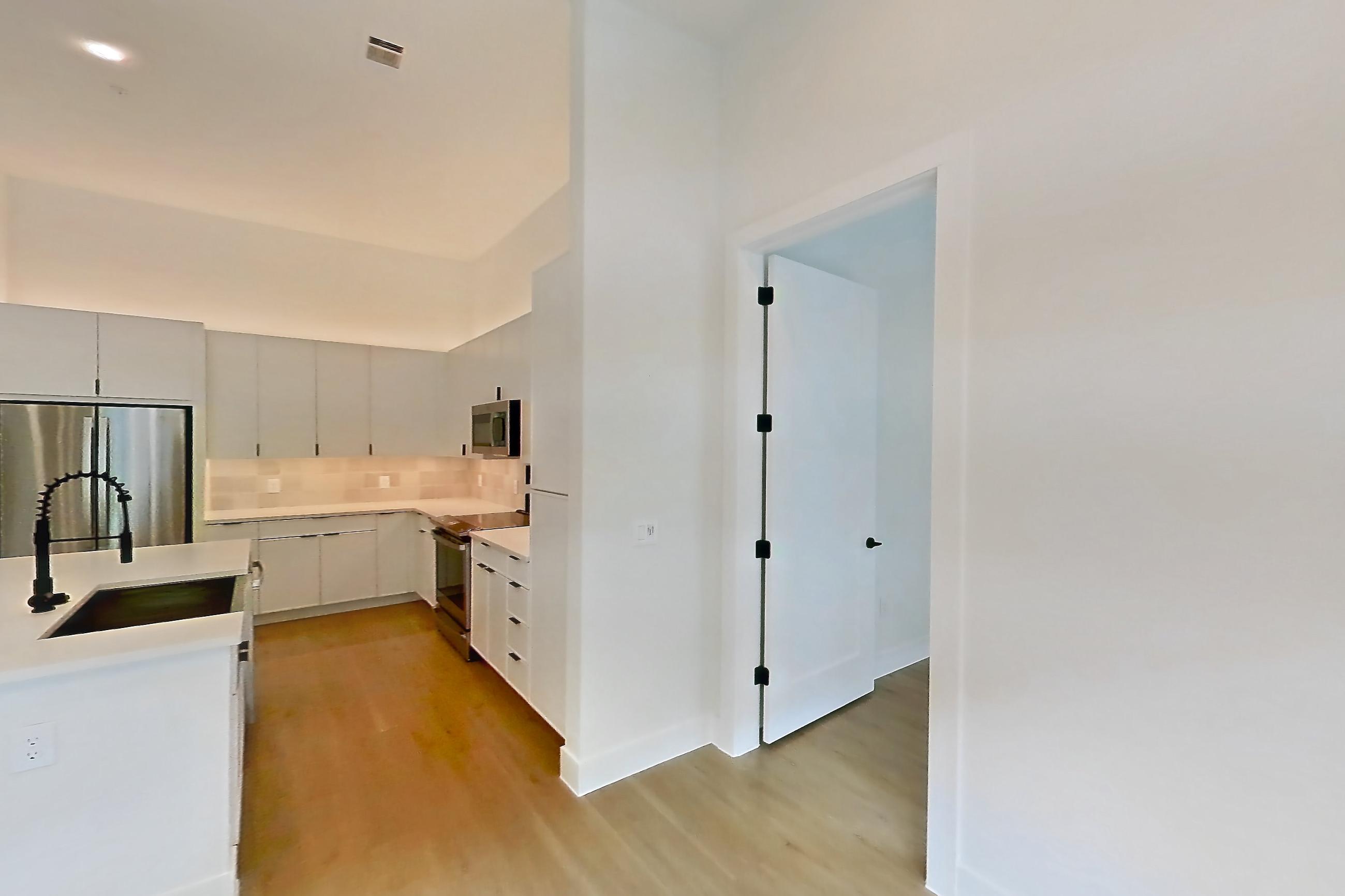 Living room with electric range, kitchen island, light countertops, and light wood-finish flooring, Apartment 120 at Lantower Midtown