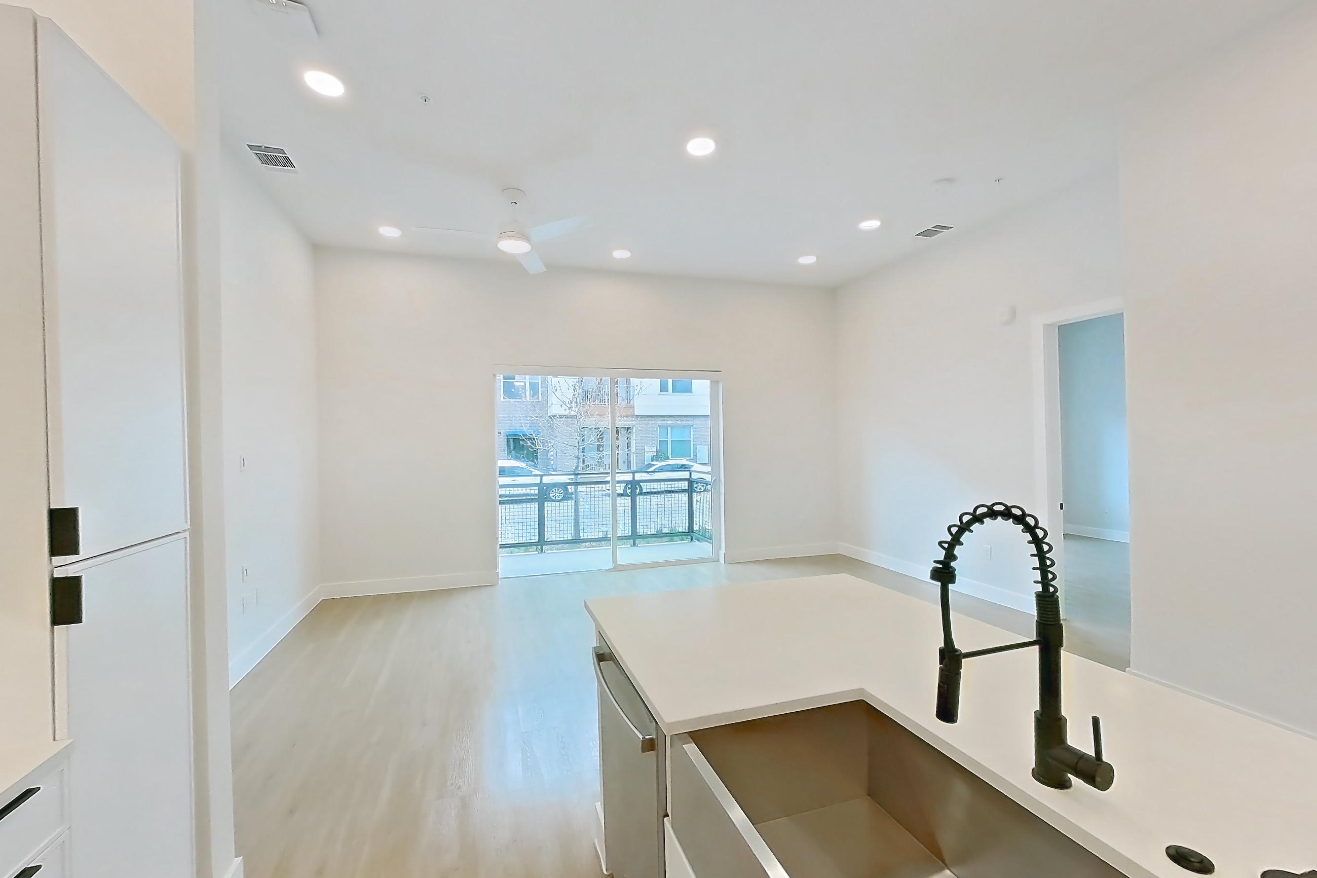 Kitchen with dishwasher, electric range, light countertops, light wood-finish flooring, microwave, oven/range, range hood, refrigerator, and stainless steel appliances, Apartment 121 at Lantower Midtown