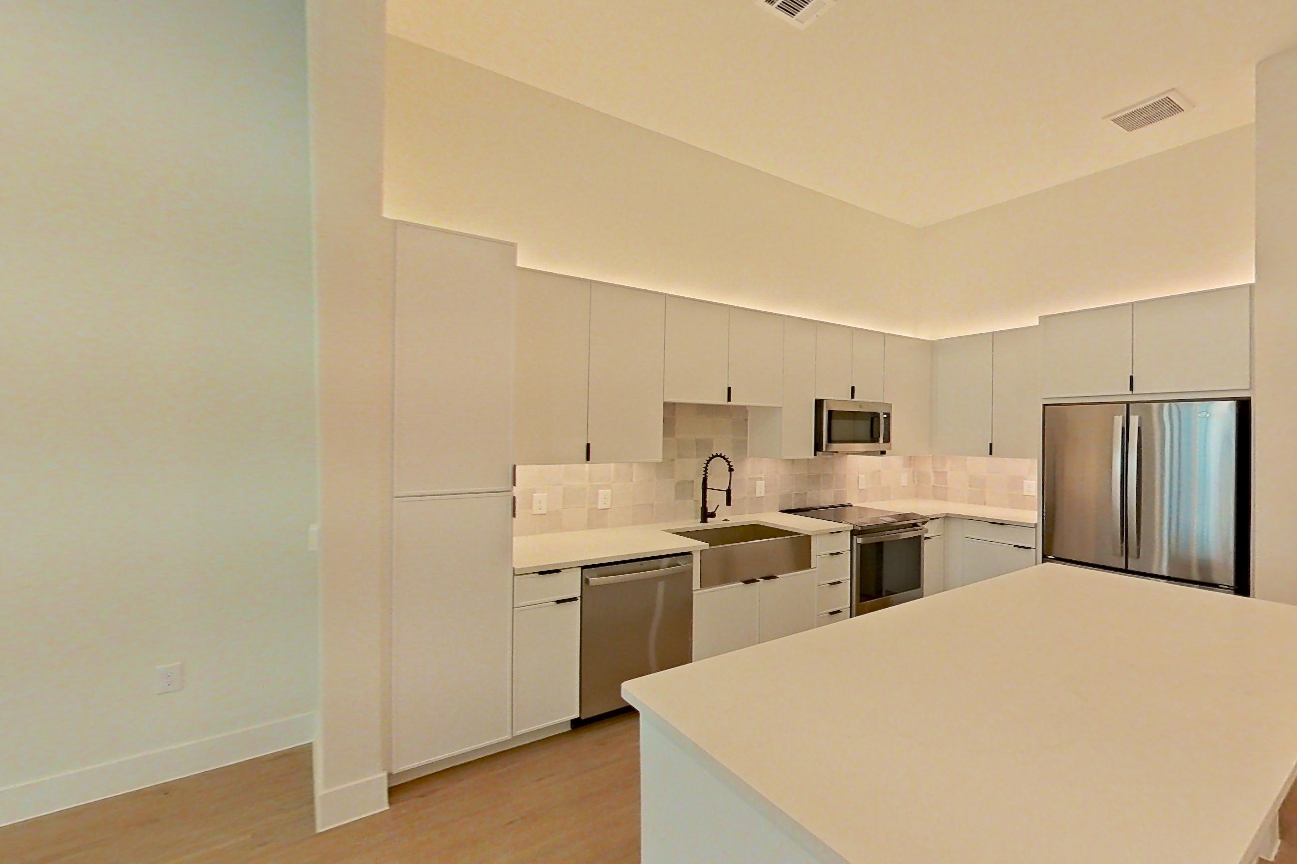 Living room with dishwasher, light countertops, light wood-finish flooring, and stainless steel appliances, Apartment 160 at Lantower Midtown