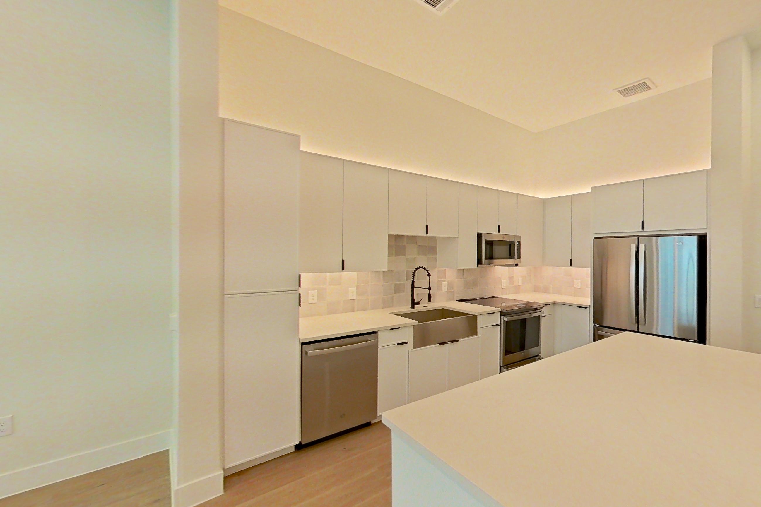 Living room with dishwasher, light countertops, light wood-finish flooring, and stainless steel appliances, Apartment 162 at Lantower Midtown