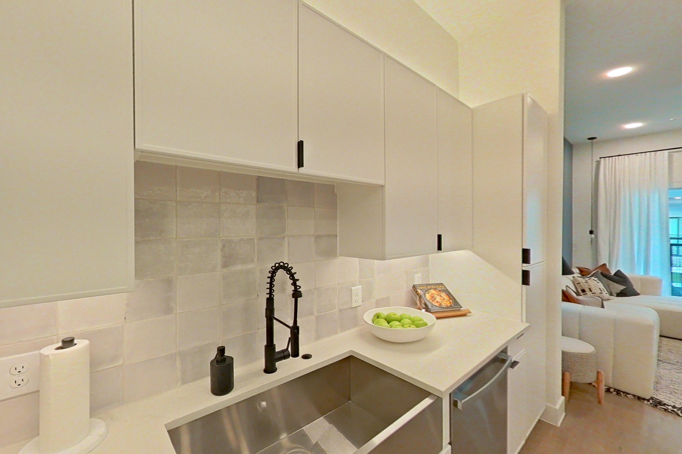 Kitchen with dishwasher, electric range, light countertops, light wood-finish flooring, microwave, refrigerator, and stainless steel appliances, Apartment 172 at Lantower Midtown