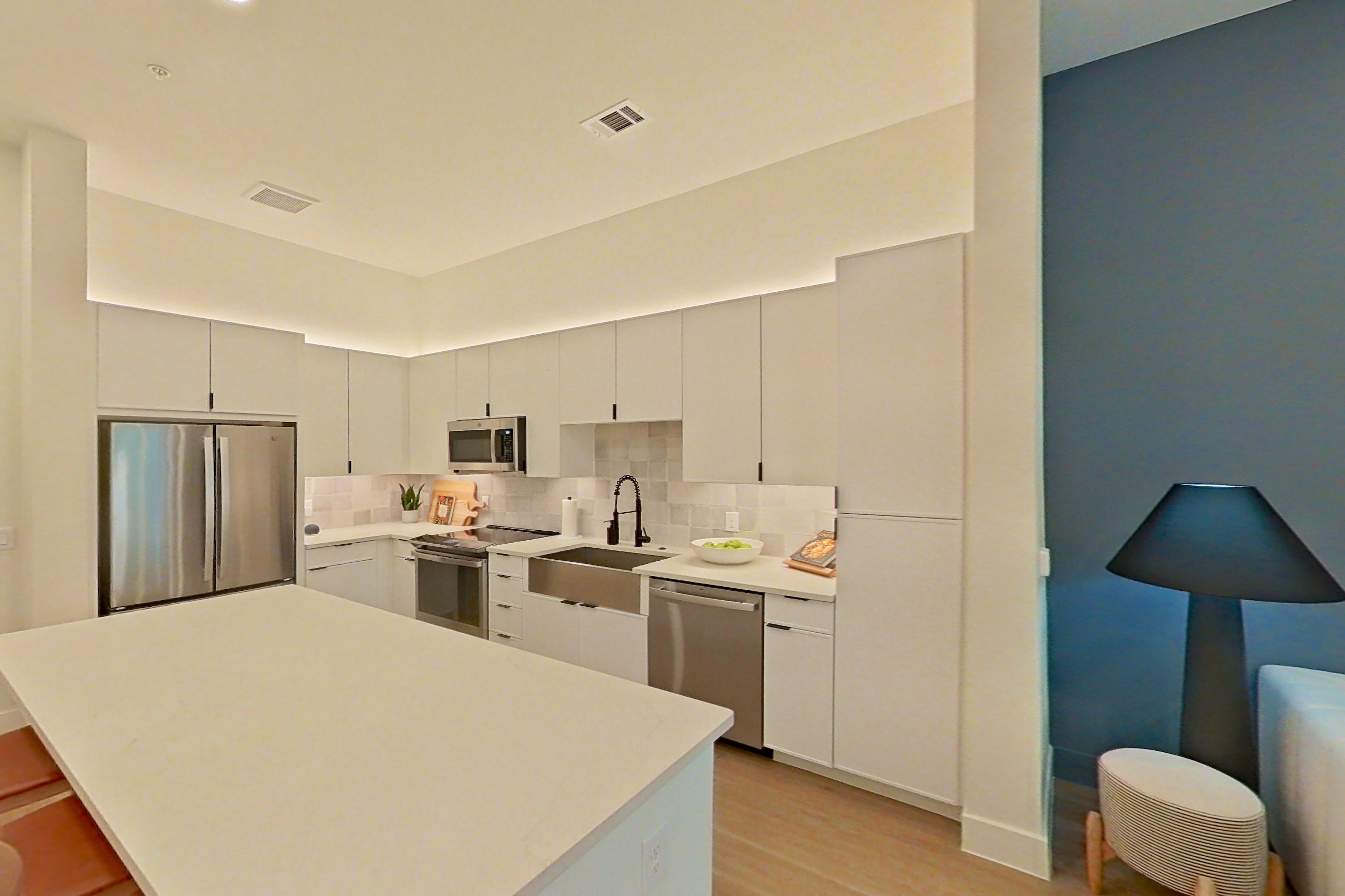 Living room with dishwasher, light wood-finish flooring, and stainless steel appliances, Apartment 172 at Lantower Midtown