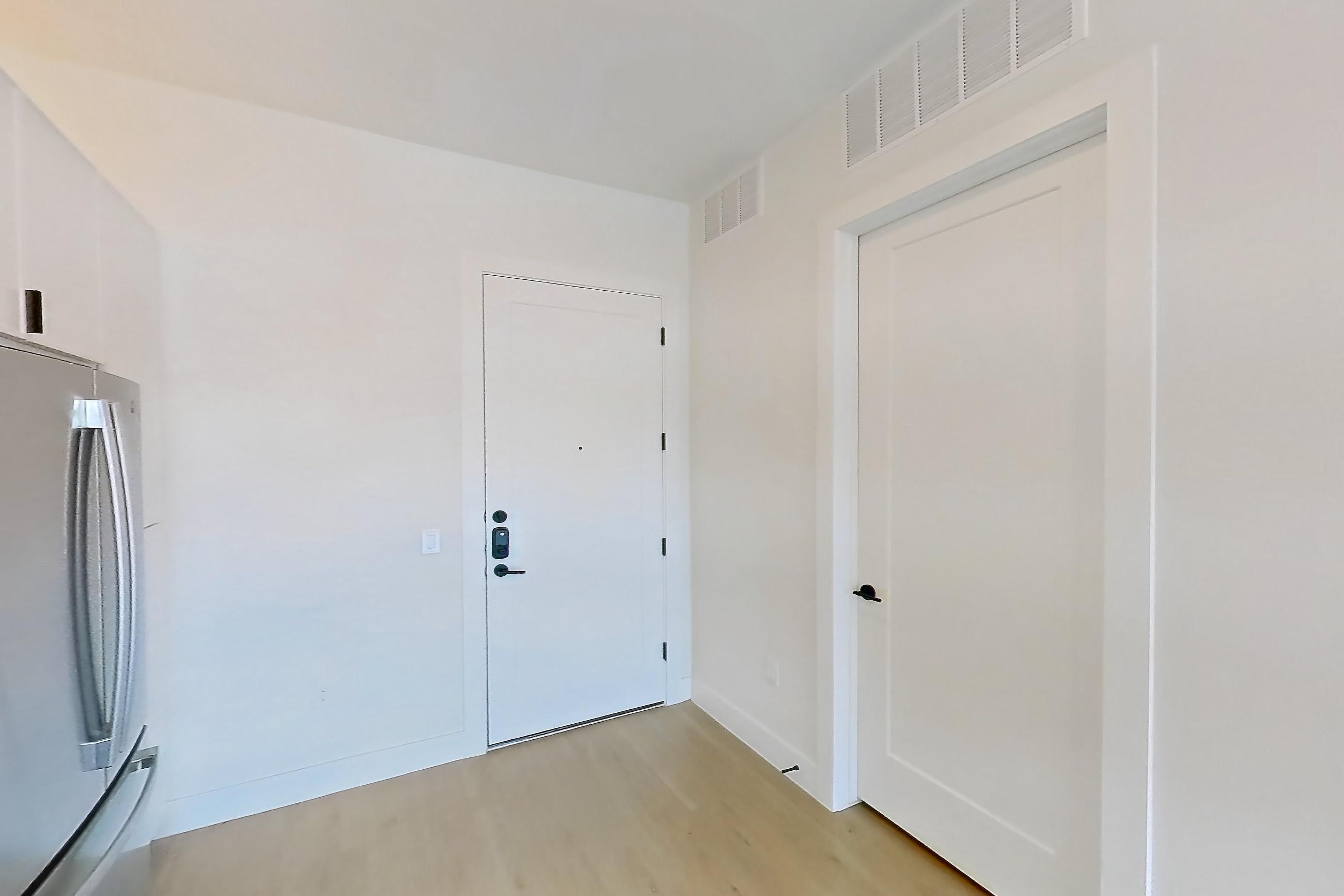 Kitchen with dishwasher, electric range, light countertops, light stone countertops, light wood-finish flooring, microwave, oven/range, refrigerator, stainless steel appliances, and wood-finish flooring, Apartment 314 at Lantower Midtown
