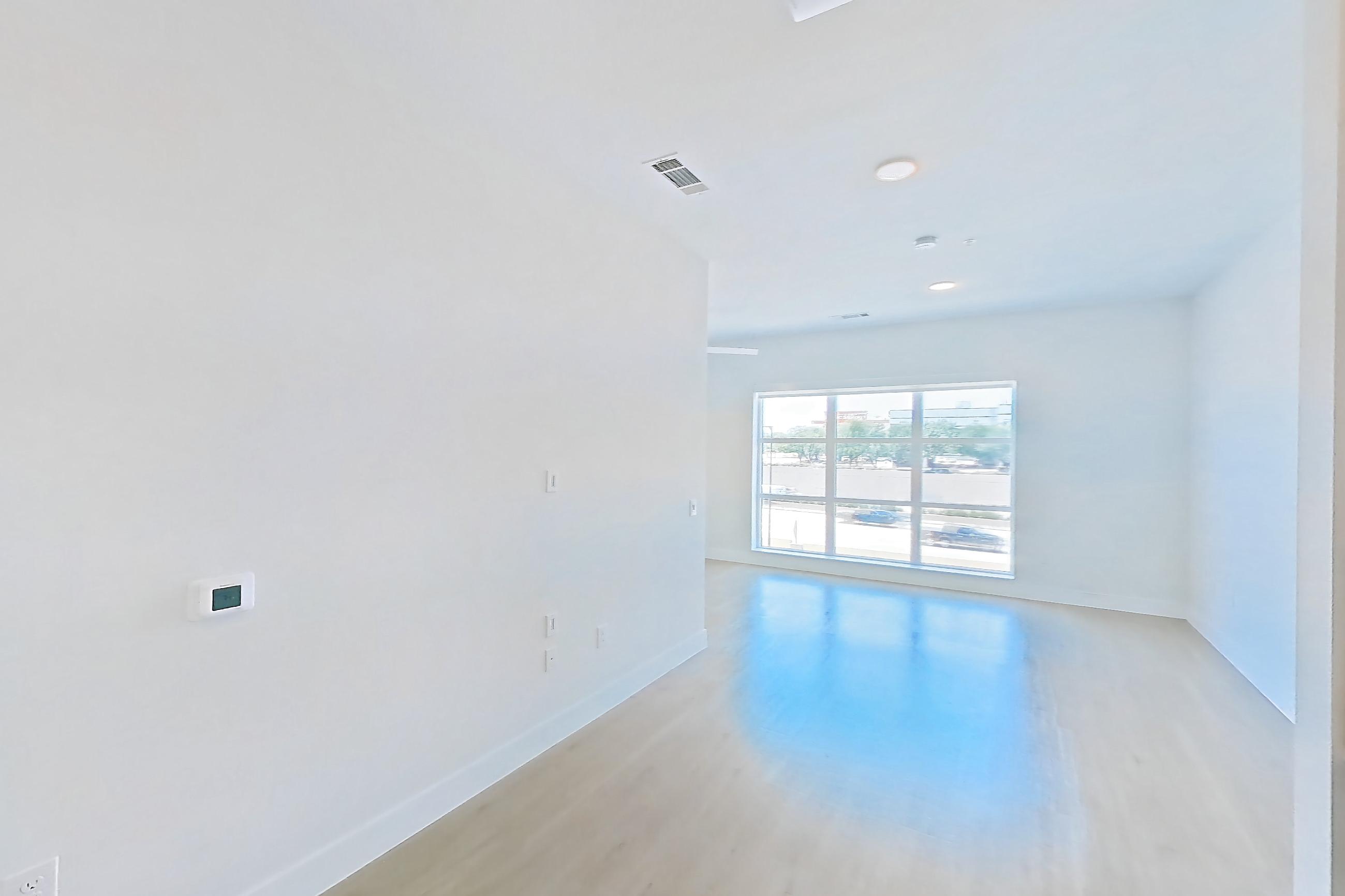 Kitchen with dishwasher, electric range, light countertops, light stone countertops, light wood-finish flooring, microwave, oven/range, refrigerator, stainless steel appliances, and wood-finish flooring, Apartment 314 at Lantower Midtown