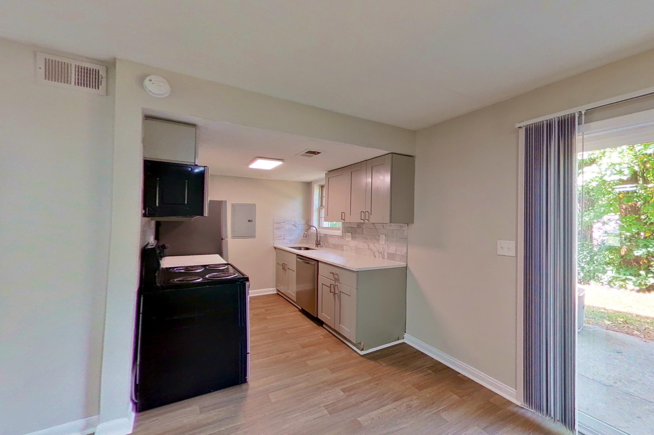 Dining area with dishwasher, electric range, light countertops, light wood-finish flooring, and stainless steel appliances, Apartment 2303 at Dunwoody Glen