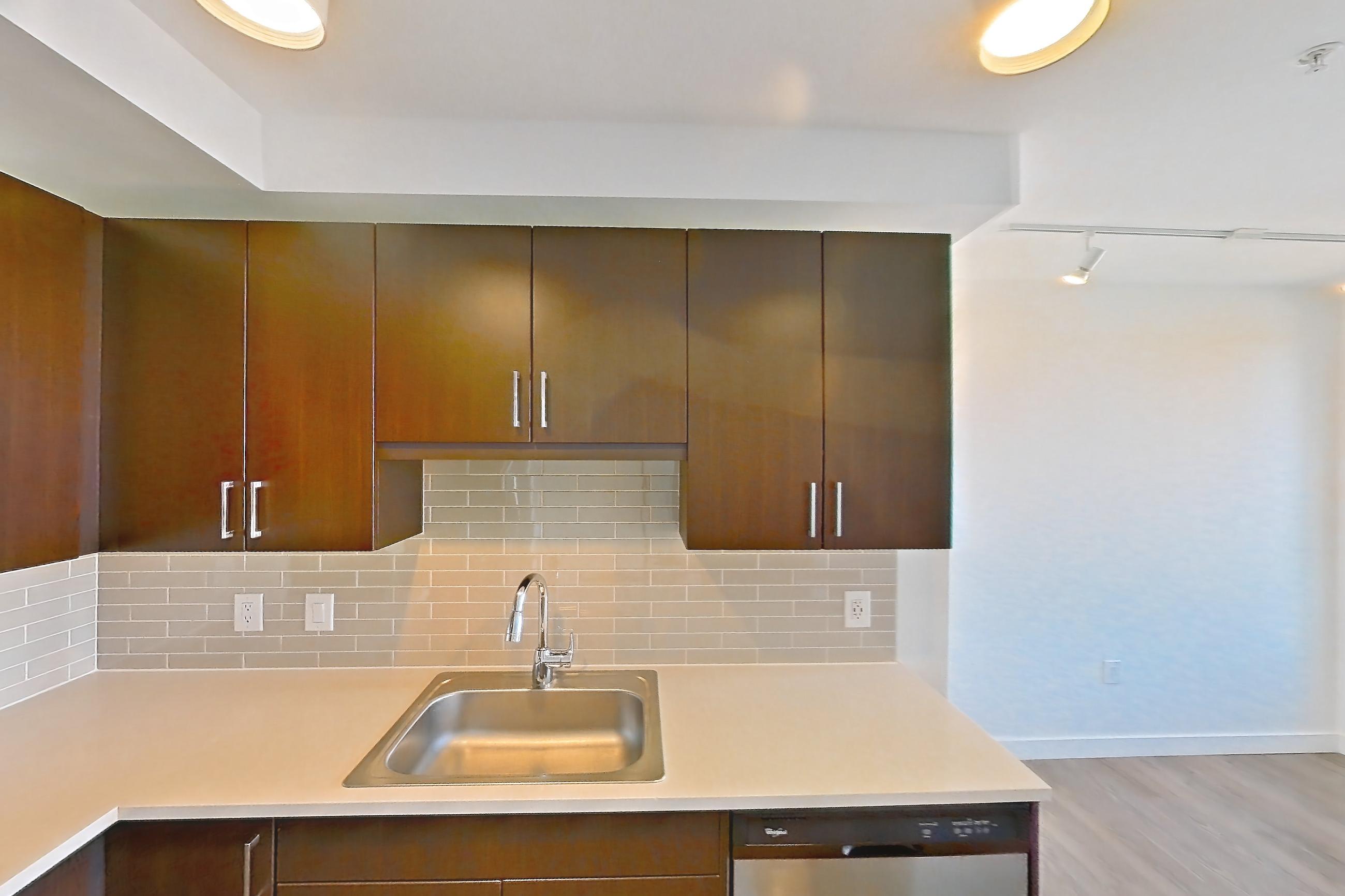 Kitchen with dishwasher, electric range, light countertops, light wood-finish flooring, microwave, oven/range, refrigerator, and stainless steel appliances, Apartment 1807 at Luka