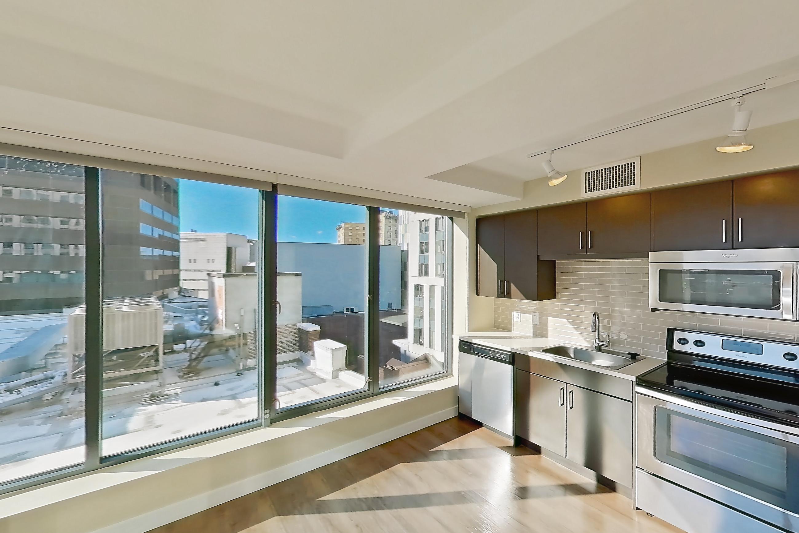Living room with city view, dark wood-finish flooring, dishwasher, light wood-finish flooring, skyline view, and stainless steel appliances, Apartment 0916 at Luka