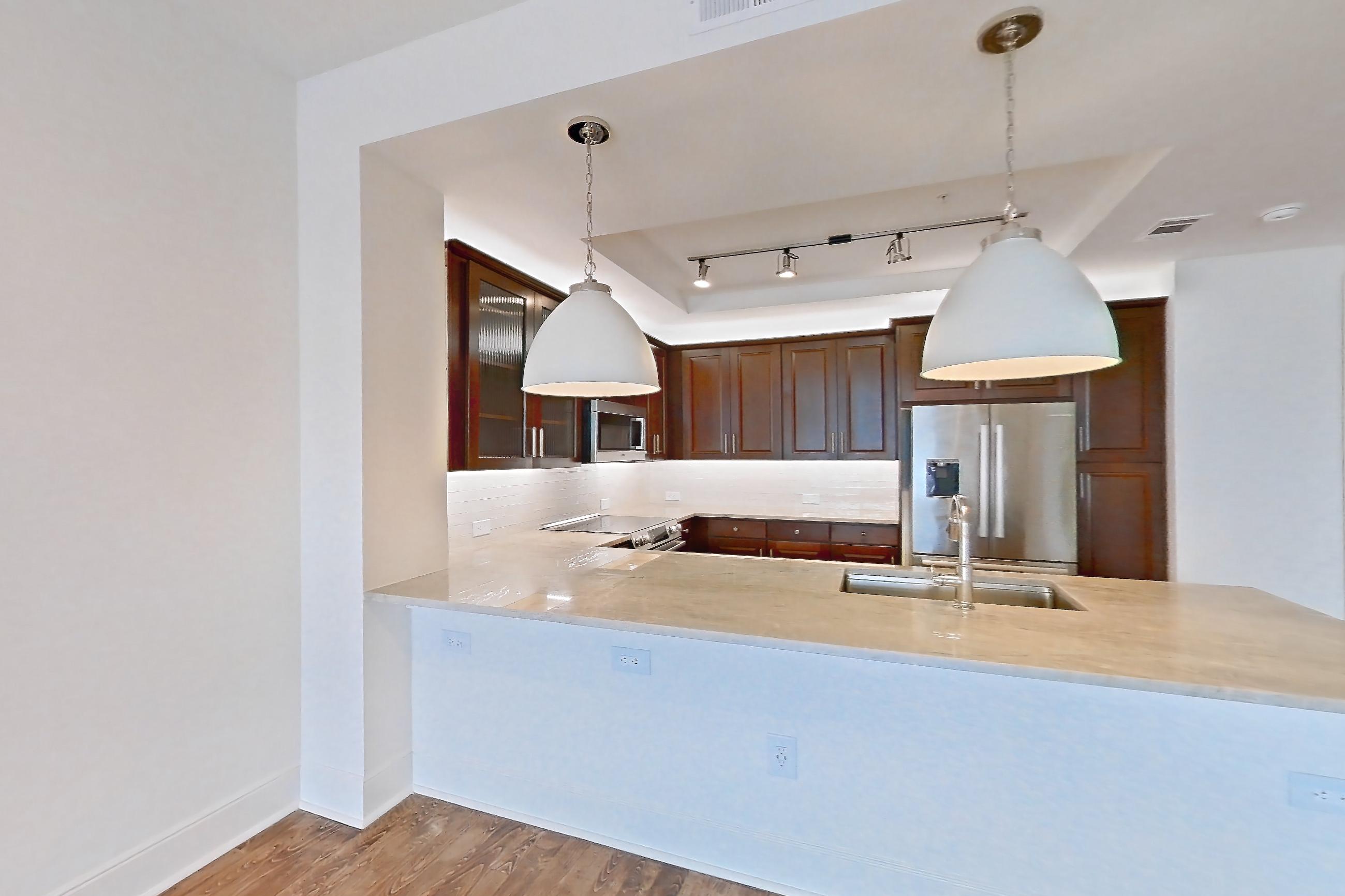 Dining room with electric range, light stone countertops, light wood-finish flooring, oven/range, refrigerator, stainless steel appliances, and wood-finish flooring, Apartment 2008 at Cortland on McKinney