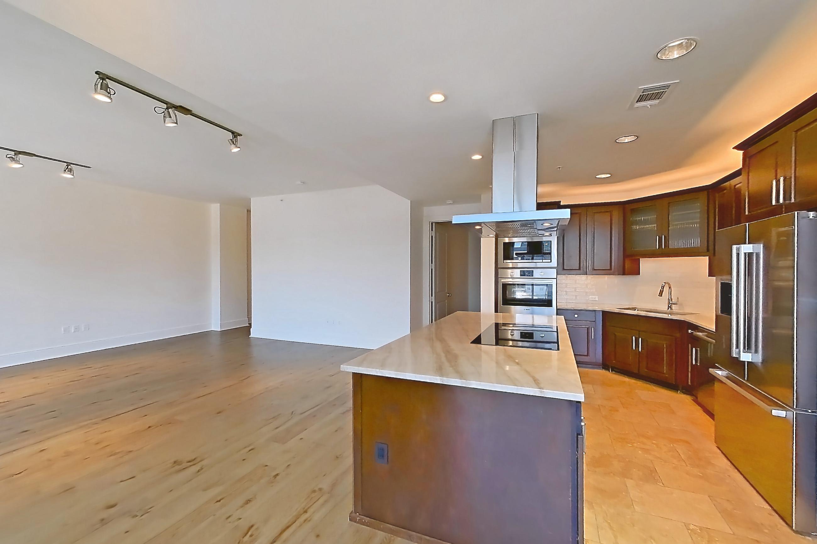 Dining room with black appliances, city view, cooktop, electric cooktop, light stone countertops, light wood-finish flooring, oven/range, and stainless steel appliances, Apartment 1507 at Cortland on McKinney