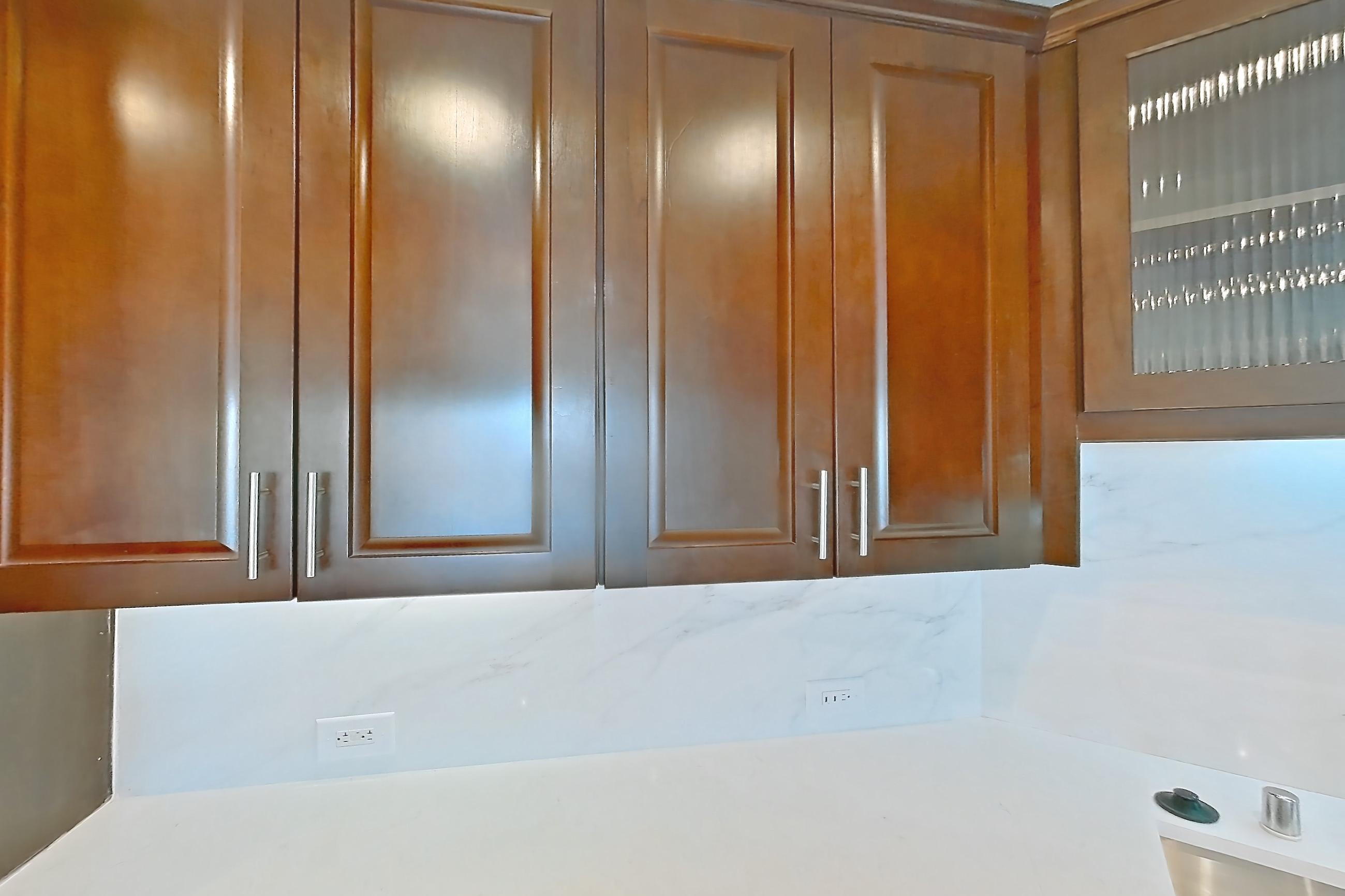 Kitchen with black appliances, cooktop, dishwasher, electric cooktop, light stone countertops, light tile flooring, microwave, oven/range, range hood, refrigerator, stainless steel appliances, and water & ice dispenser, Apartment 1809 at Cortland on McKinney