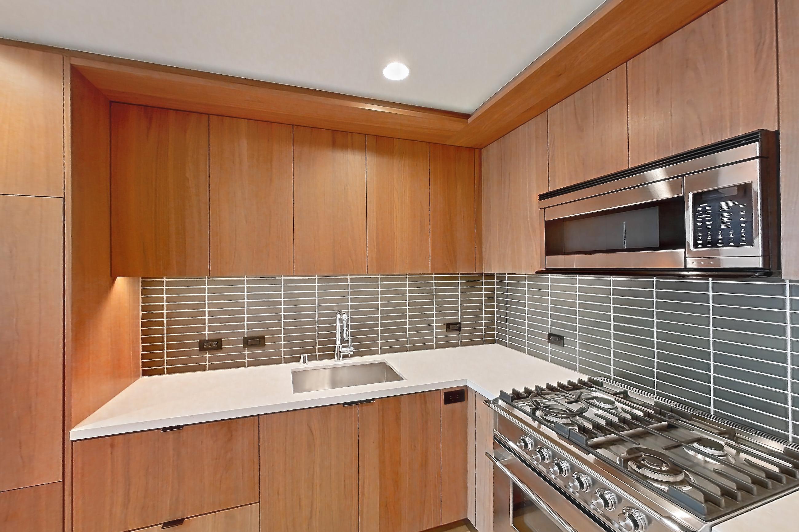 Kitchen with gas range, light stone countertops, light wood-finish flooring, oven/range, and stainless steel appliances, Apartment B-3004 at Beaudry