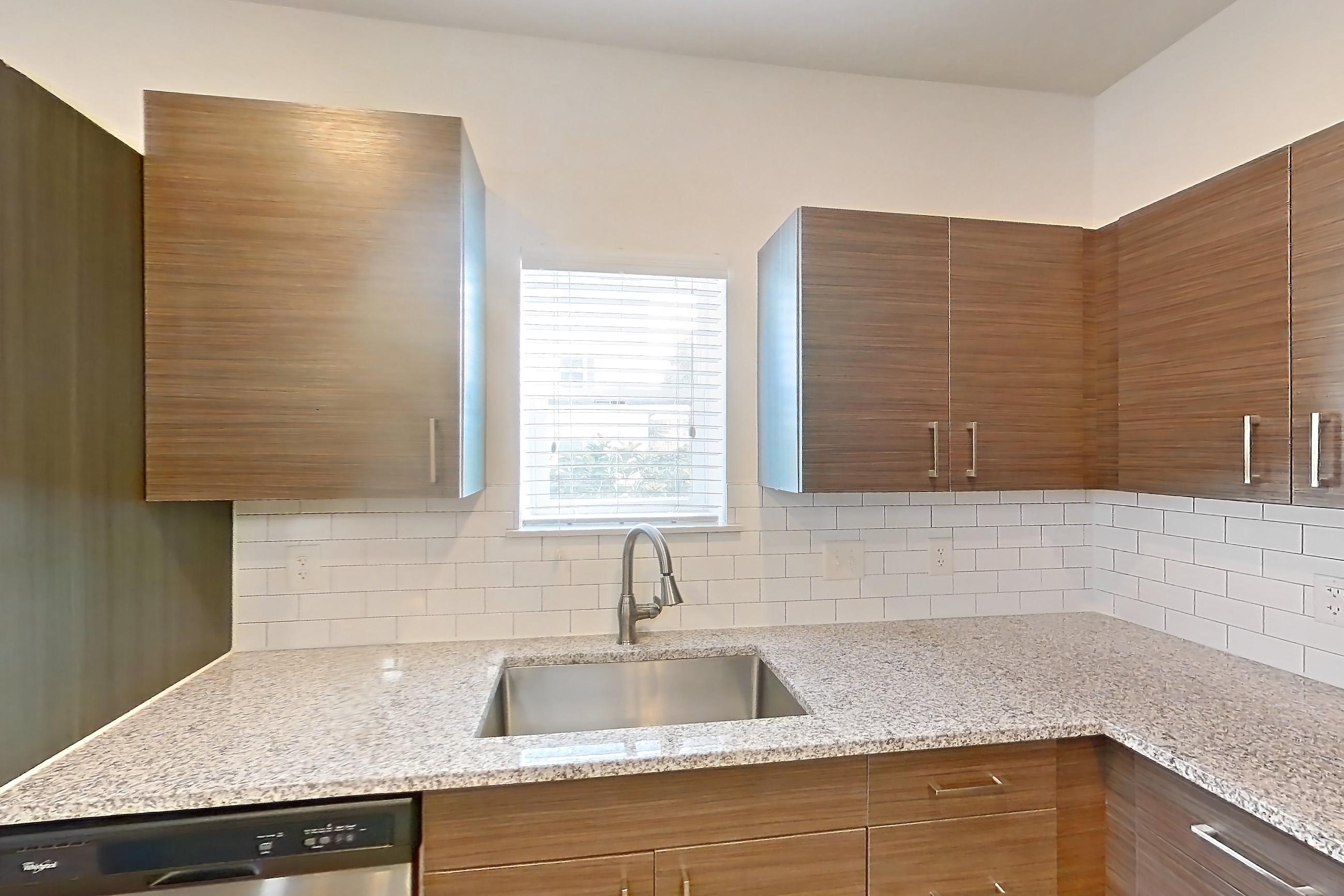 Kitchen with dishwasher, light stone countertops, light wood-finish flooring, oven/range, refrigerator, and stainless steel appliances, Apartment 150-104 at Domain