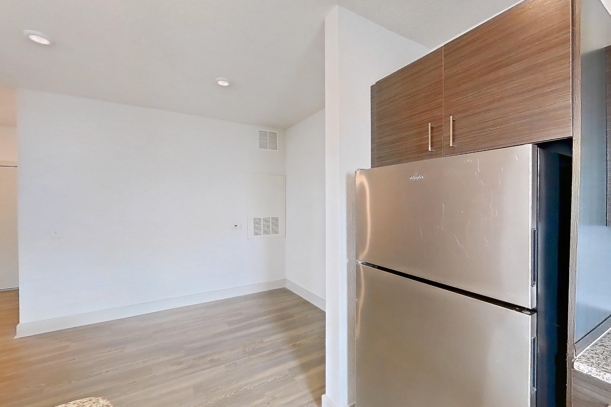 Kitchen with dishwasher, light stone countertops, light wood-finish flooring, refrigerator, and stainless steel appliances, Apartment 156-303 at Domain