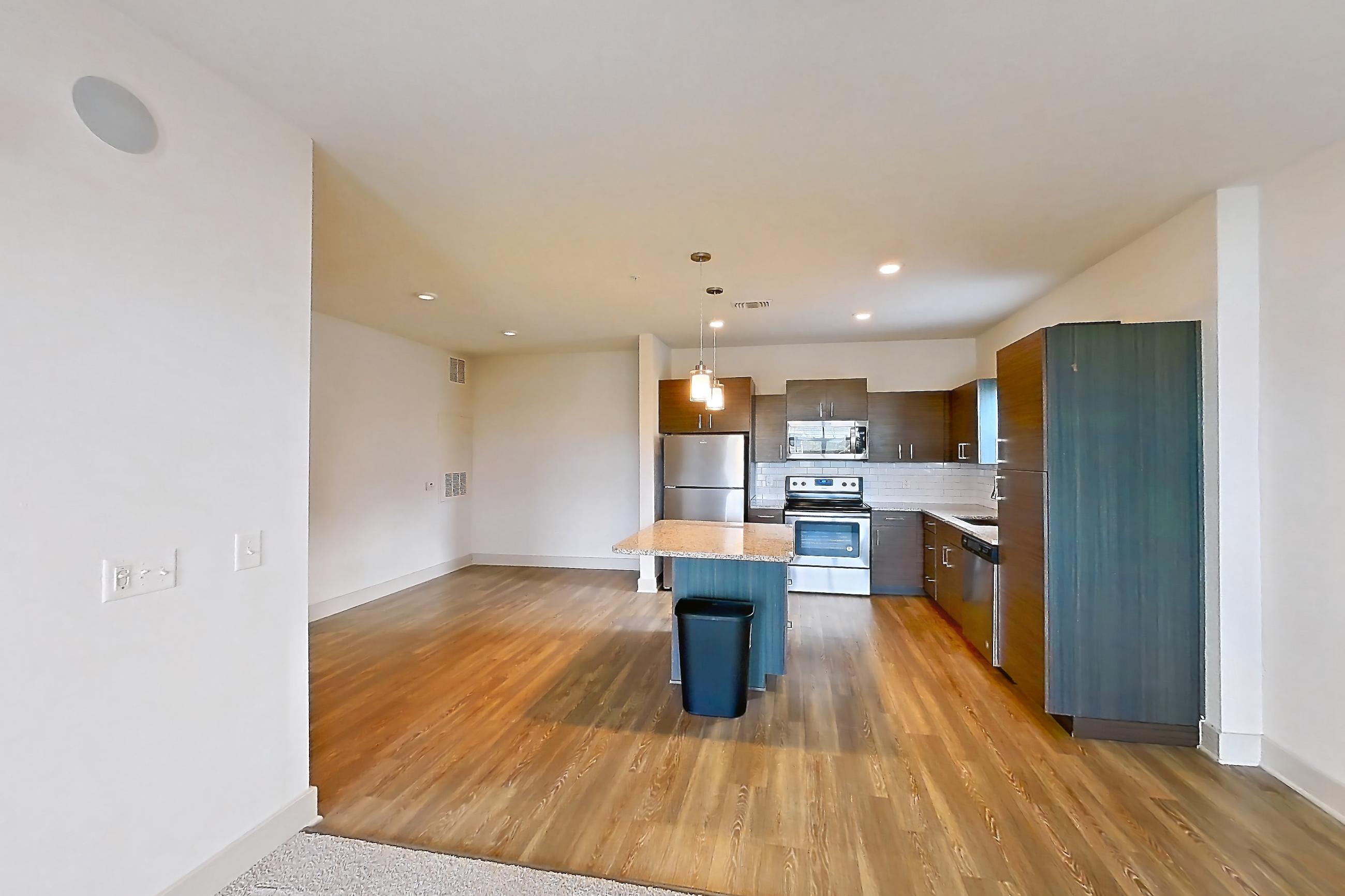 Living room with electric range, light stone countertops, oven/range, refrigerator, and stainless steel appliances, Apartment 156-303 at Domain